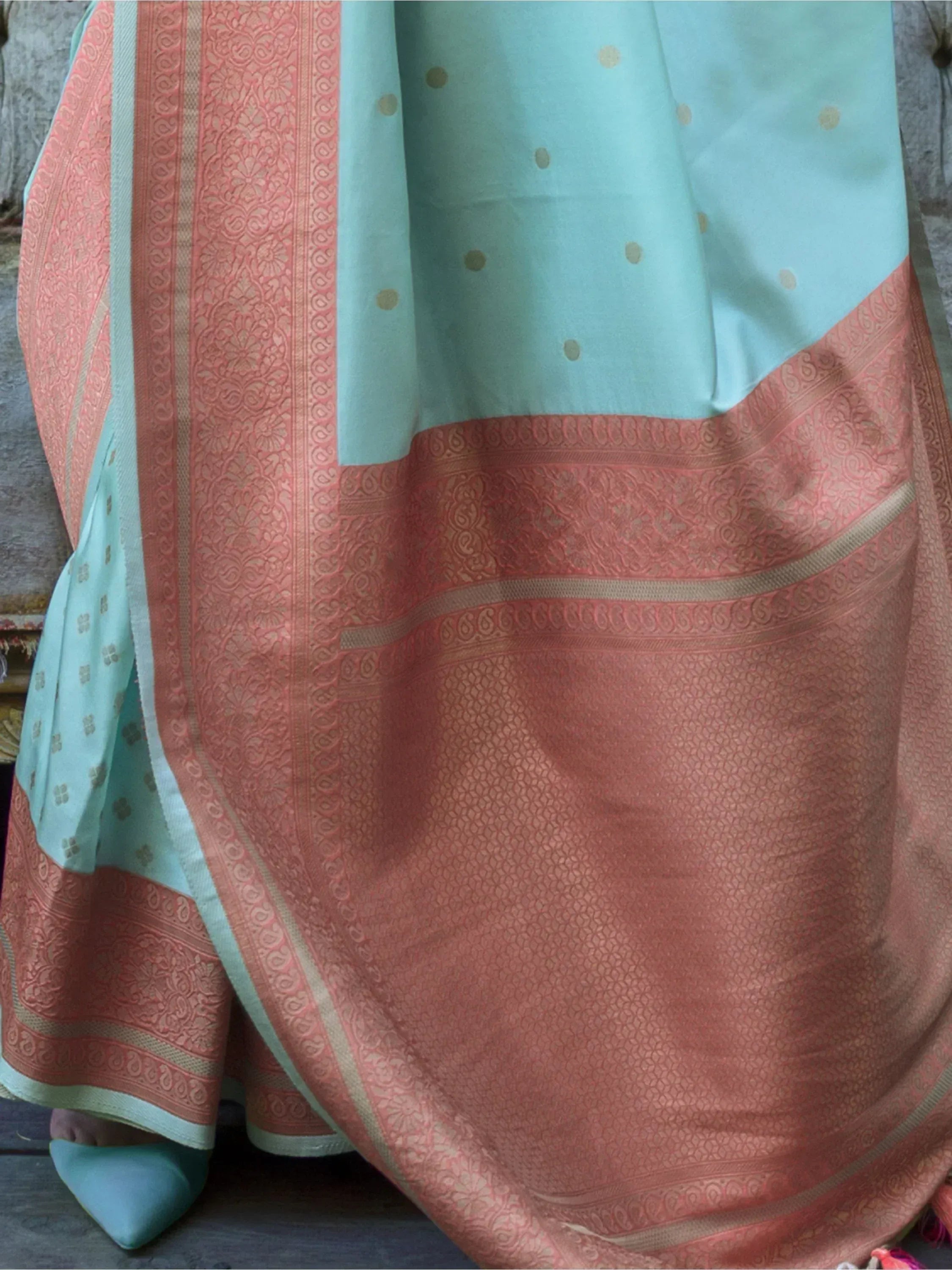 Mint green and coral designer saree with intricate gold border and polka dot pattern, perfect for ethnic occasions.