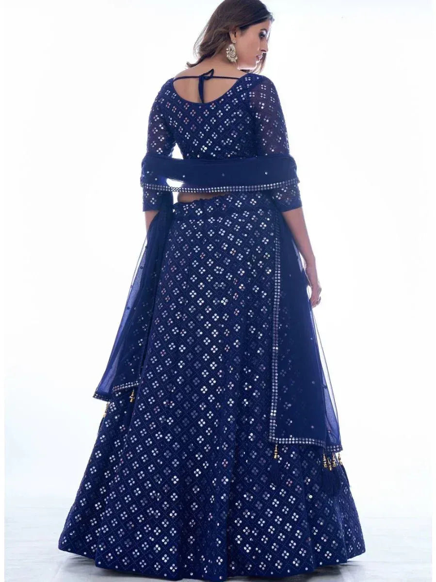 Navy blue sequin lehenga choli with sheer sleeves and back tie detail, perfect for Indian ethnic occasions.