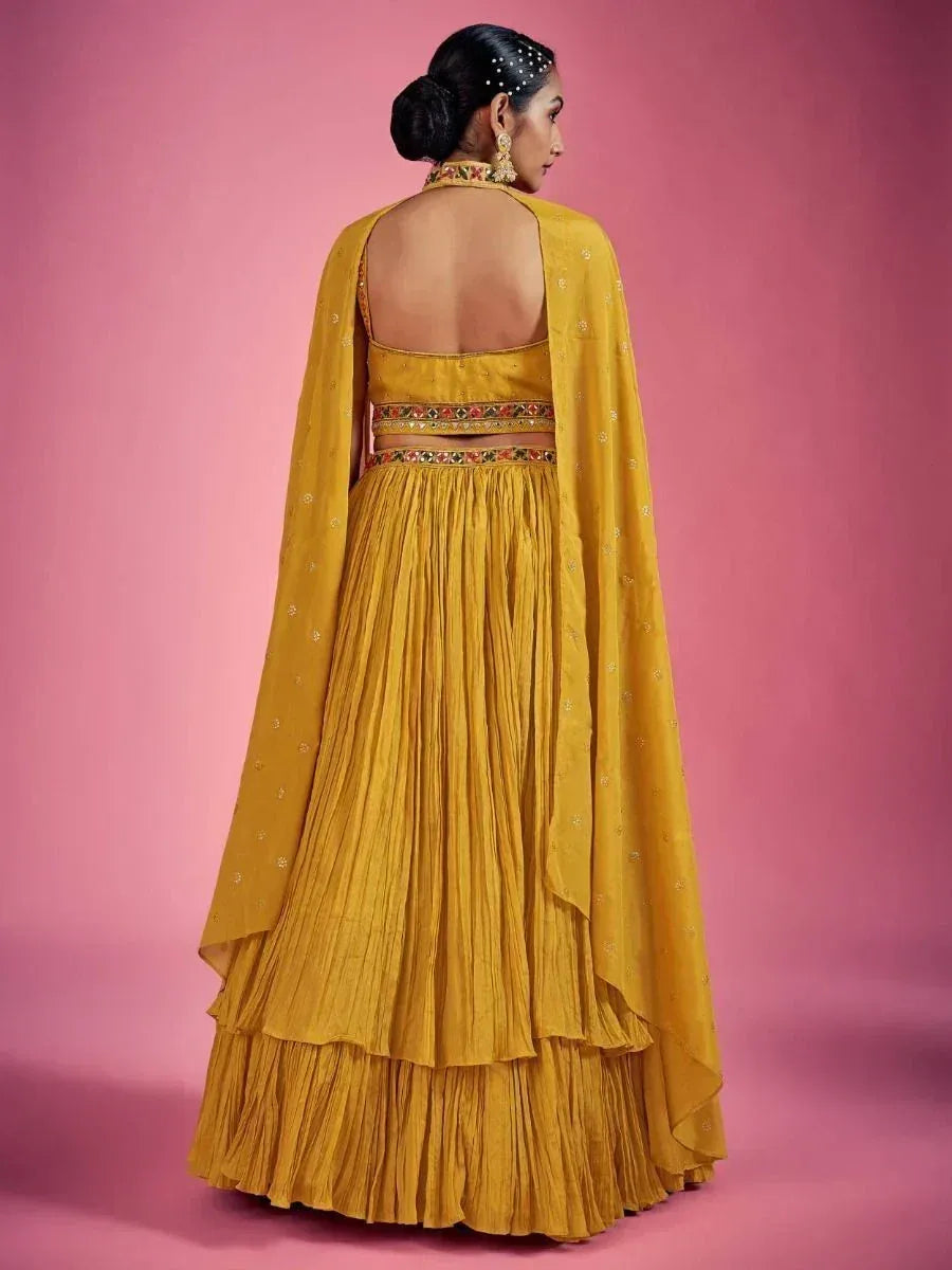 Mustard yellow lehenga choli with open back, pleated skirt, and embroidered dupatta for Indian ethnic wear