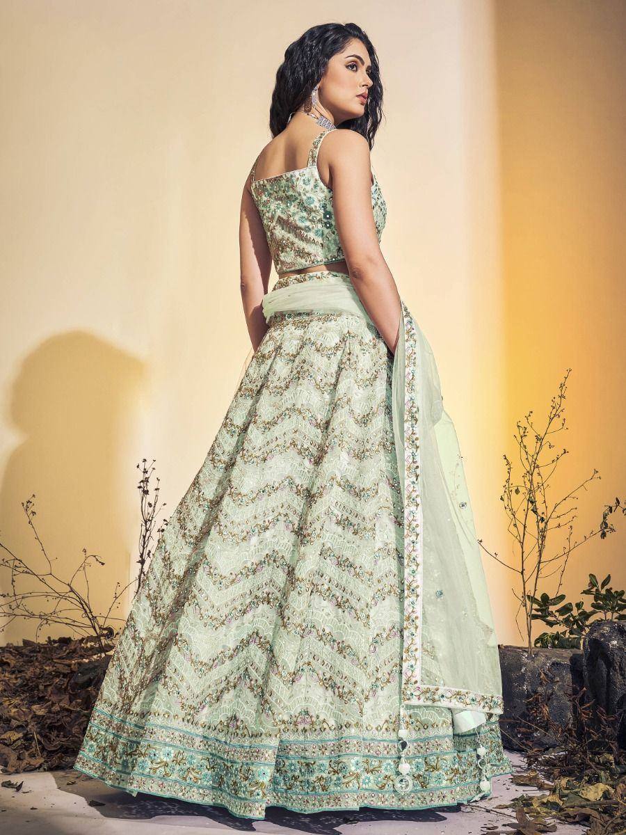 Mint green designer lehenga choli with intricate embroidery and scalloped border, perfect for weddings or festive occasions.