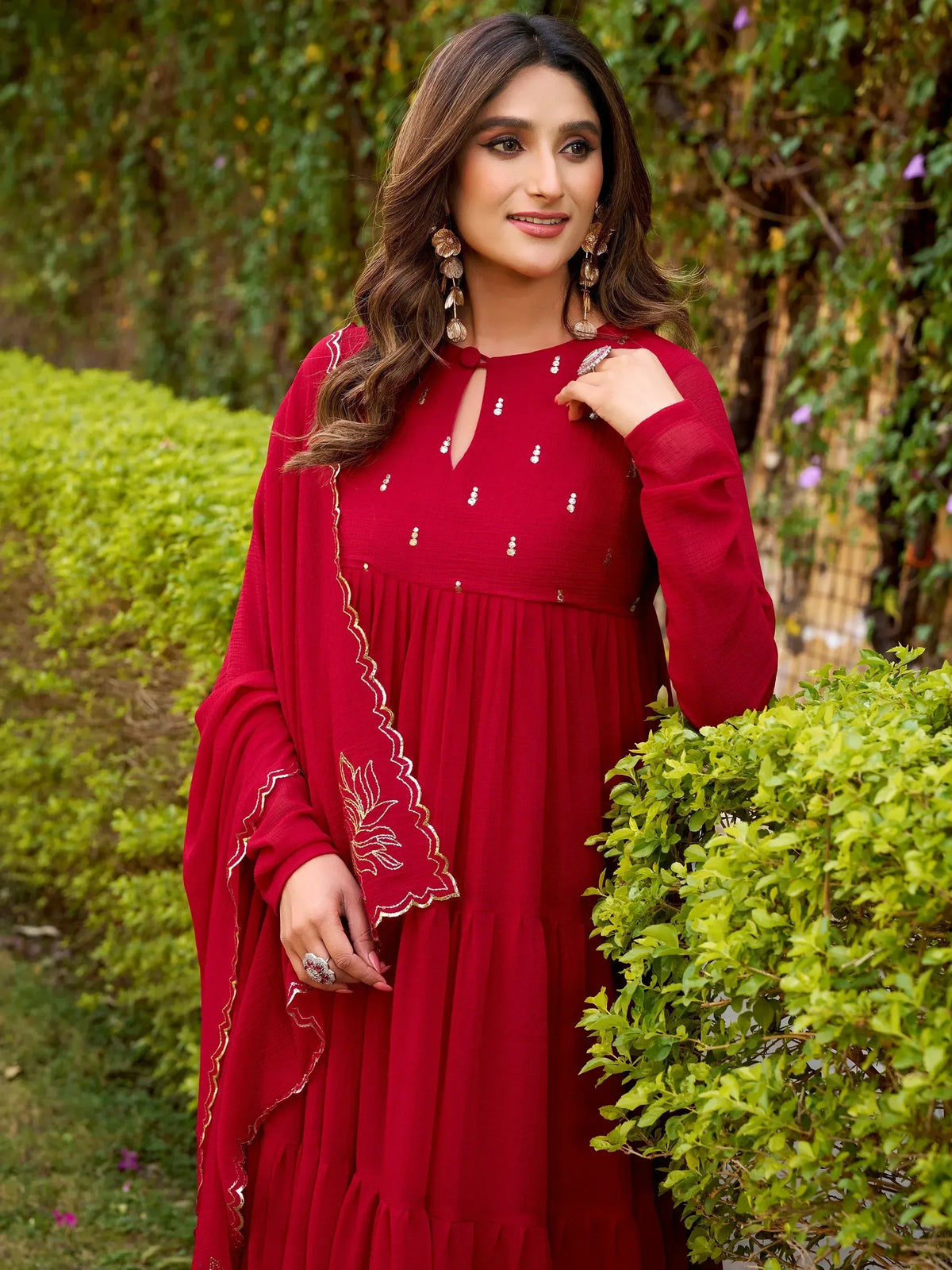 Red ethnic gown with gold embroidery and floral detailing, perfect for festive occasions