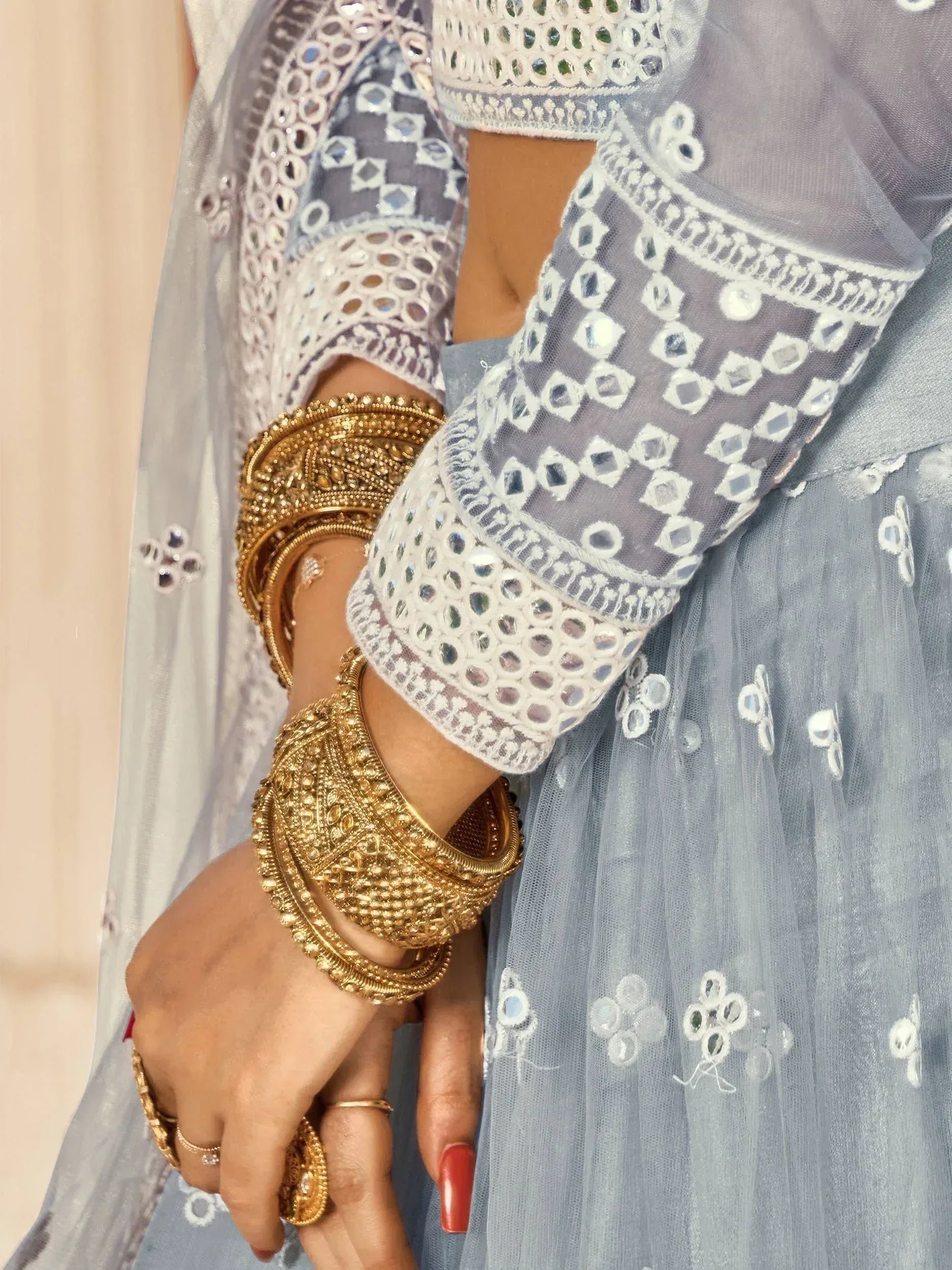 Grey mirror work lehenga choli with gold bangles, ethnic Indian bridal wear