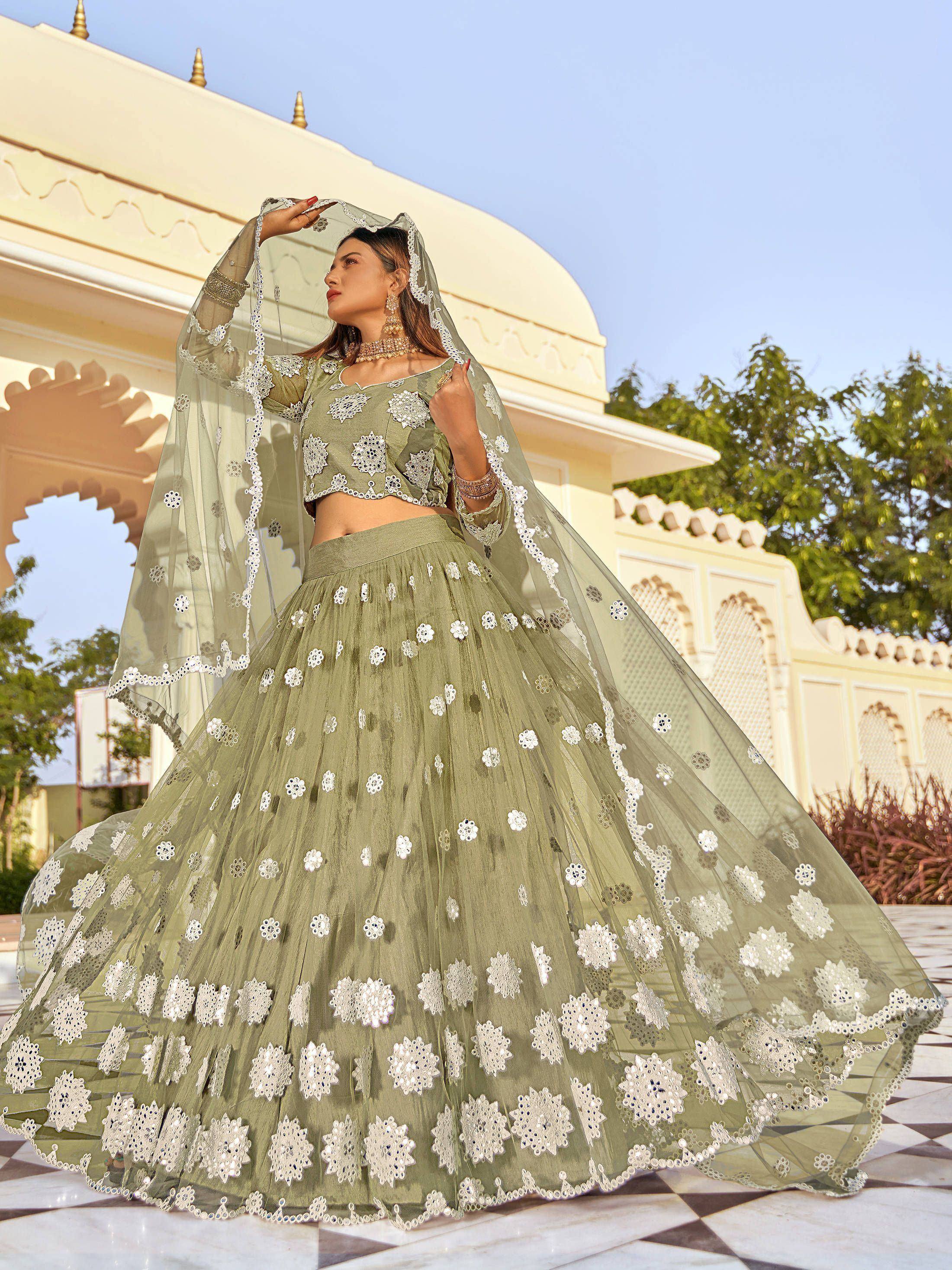 Olive green designer lehenga choli with white floral embroidery and sheer dupatta, perfect for Indian weddings or festive occasions.