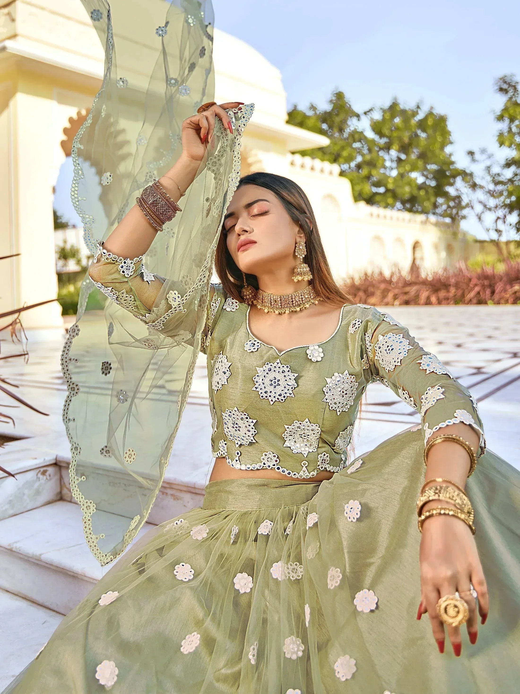 Olive green designer lehenga choli with floral embroidery and sheer dupatta, perfect for Indian ethnic occasions.