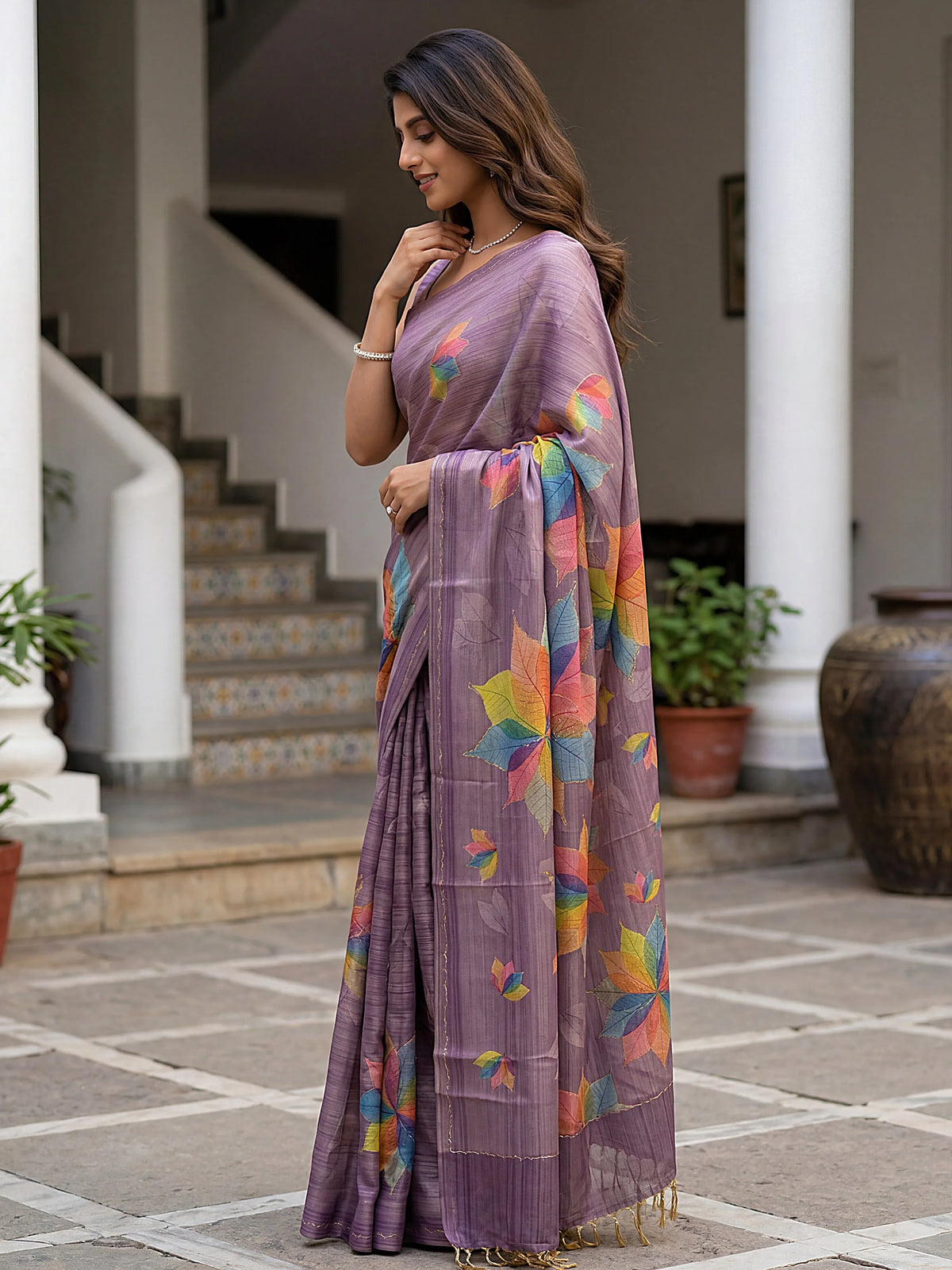 Woman wearing a purple designer saree with colorful floral prints in an outdoor setting