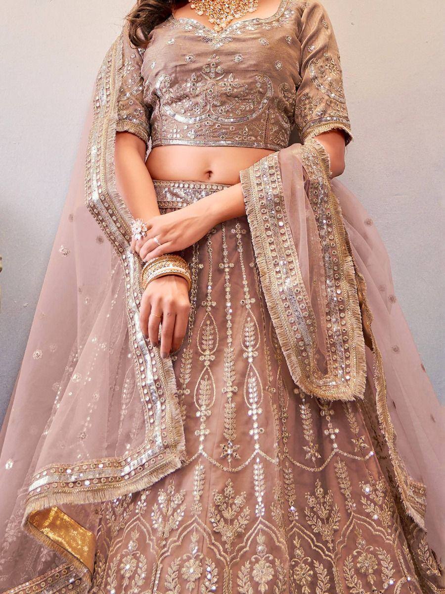 Elegant beige lehenga choli with intricate gold embroidery and sequin detailing, perfect for weddings and festive occasions.