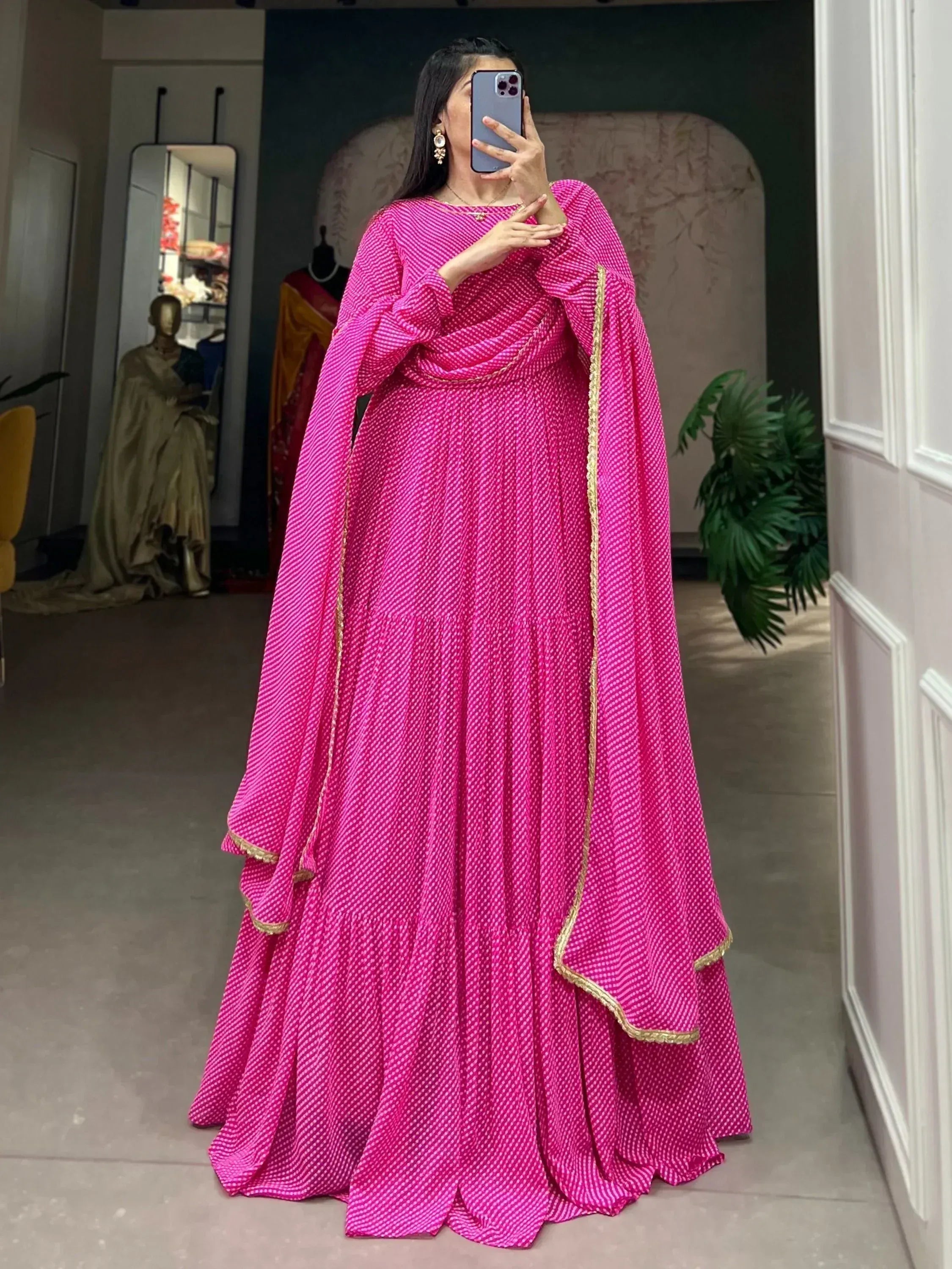 Vibrant pink ethnic gown with gold trim, perfect for Indian occasions and festive wear.