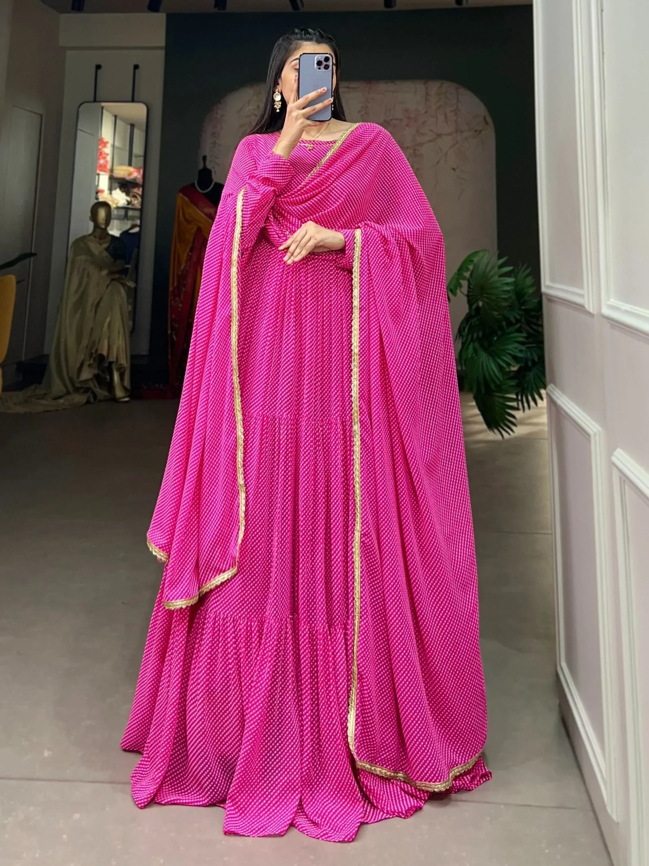Vibrant pink ethnic gown with gold trim, perfect for Indian occasions and festive wear.