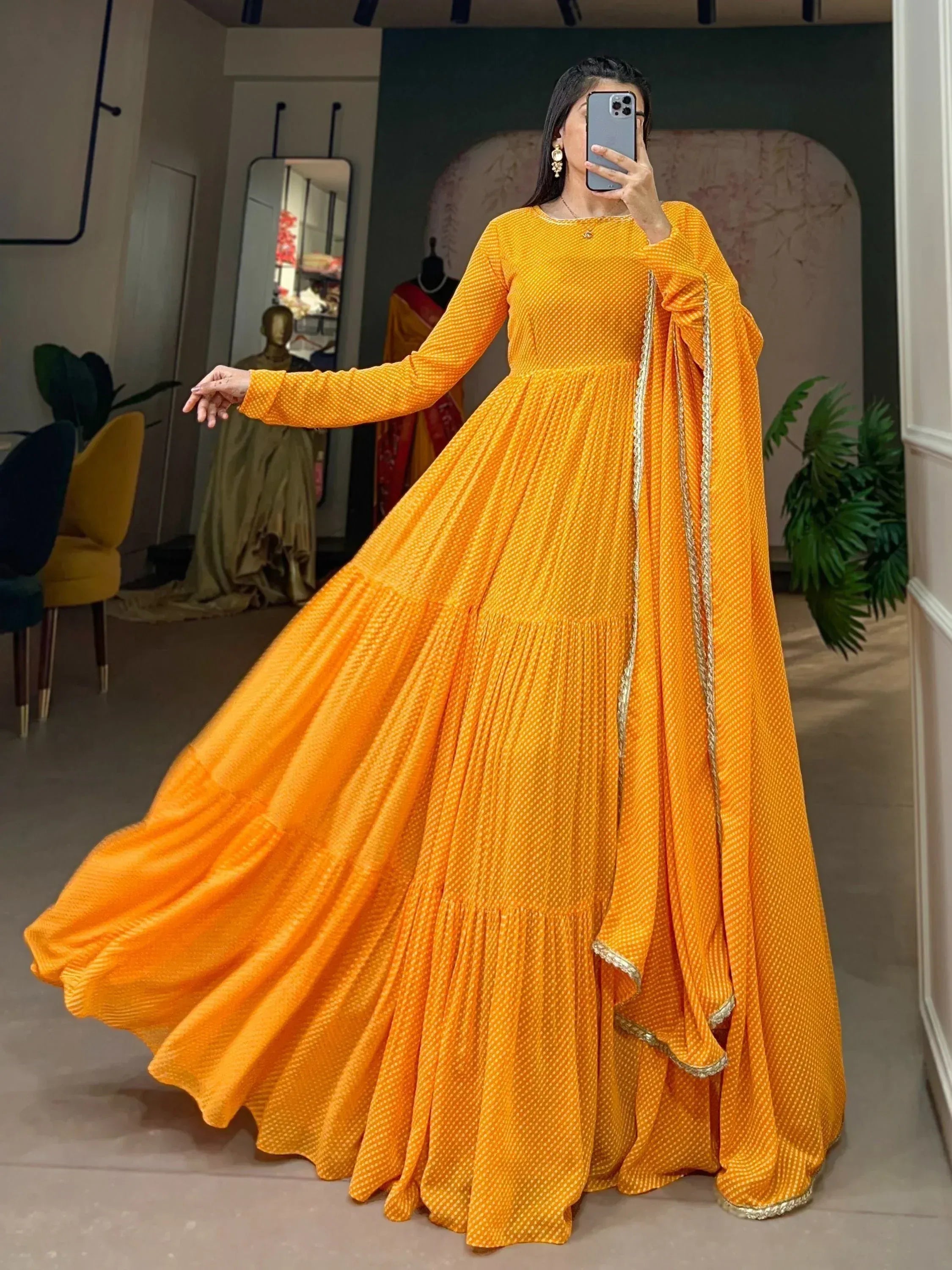 Vibrant yellow ethnic gown with gold trim, long sleeves, and flared skirt for festive occasions