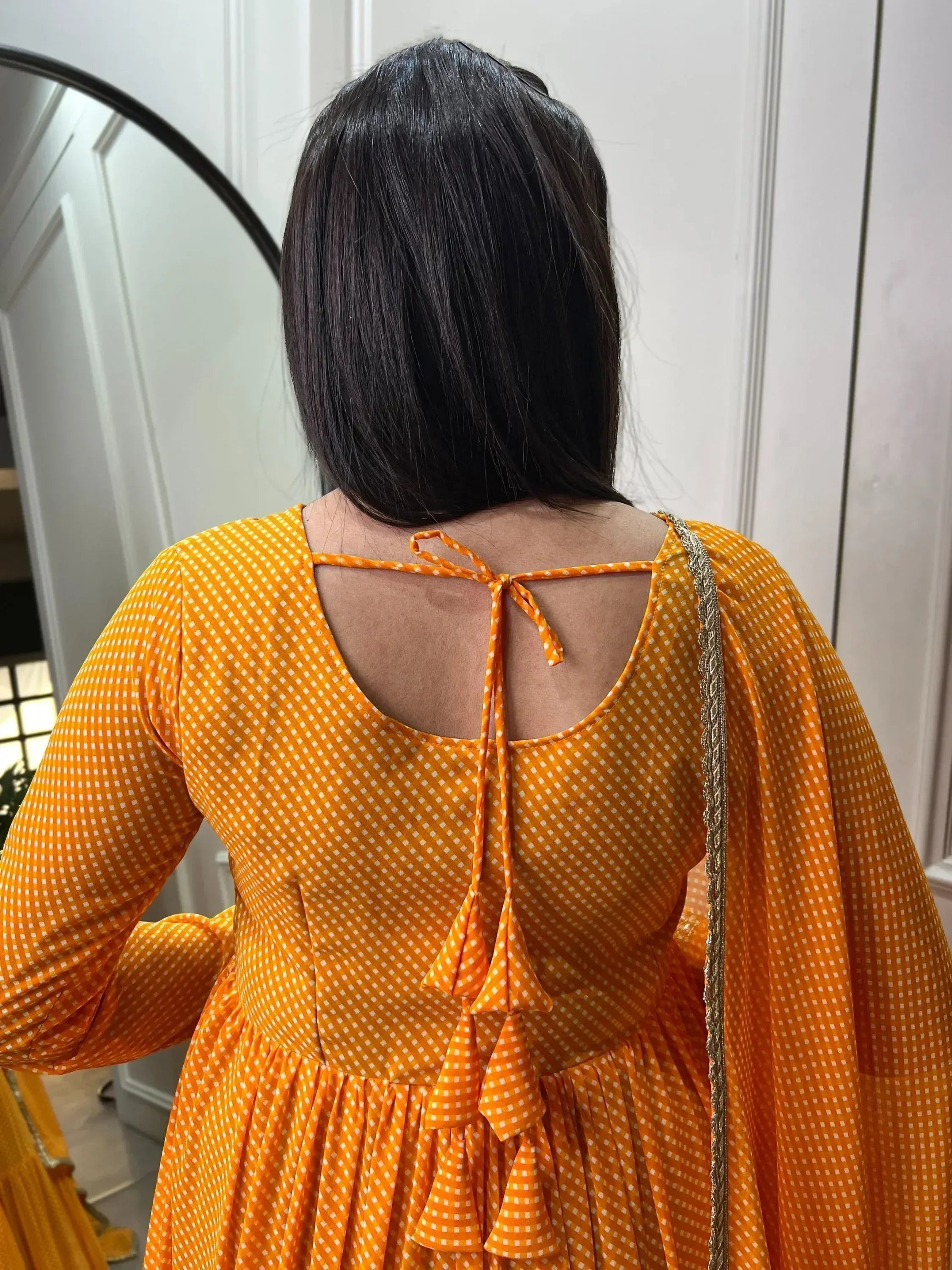 Orange polka dot ethnic gown with back tie detail, perfect for Indian occasions