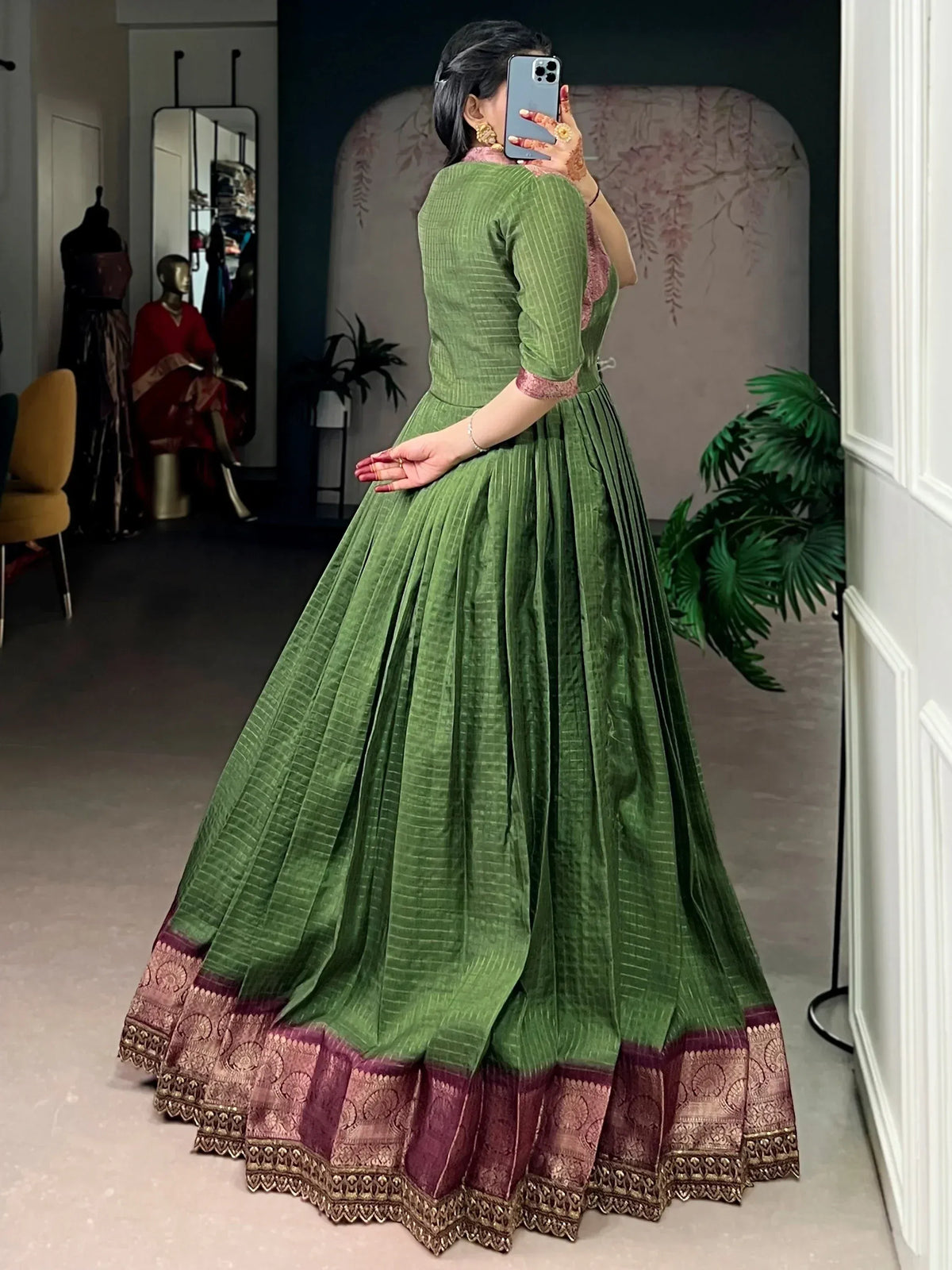 Green ethnic gown with pleated skirt and maroon gold border, perfect for Indian occasions