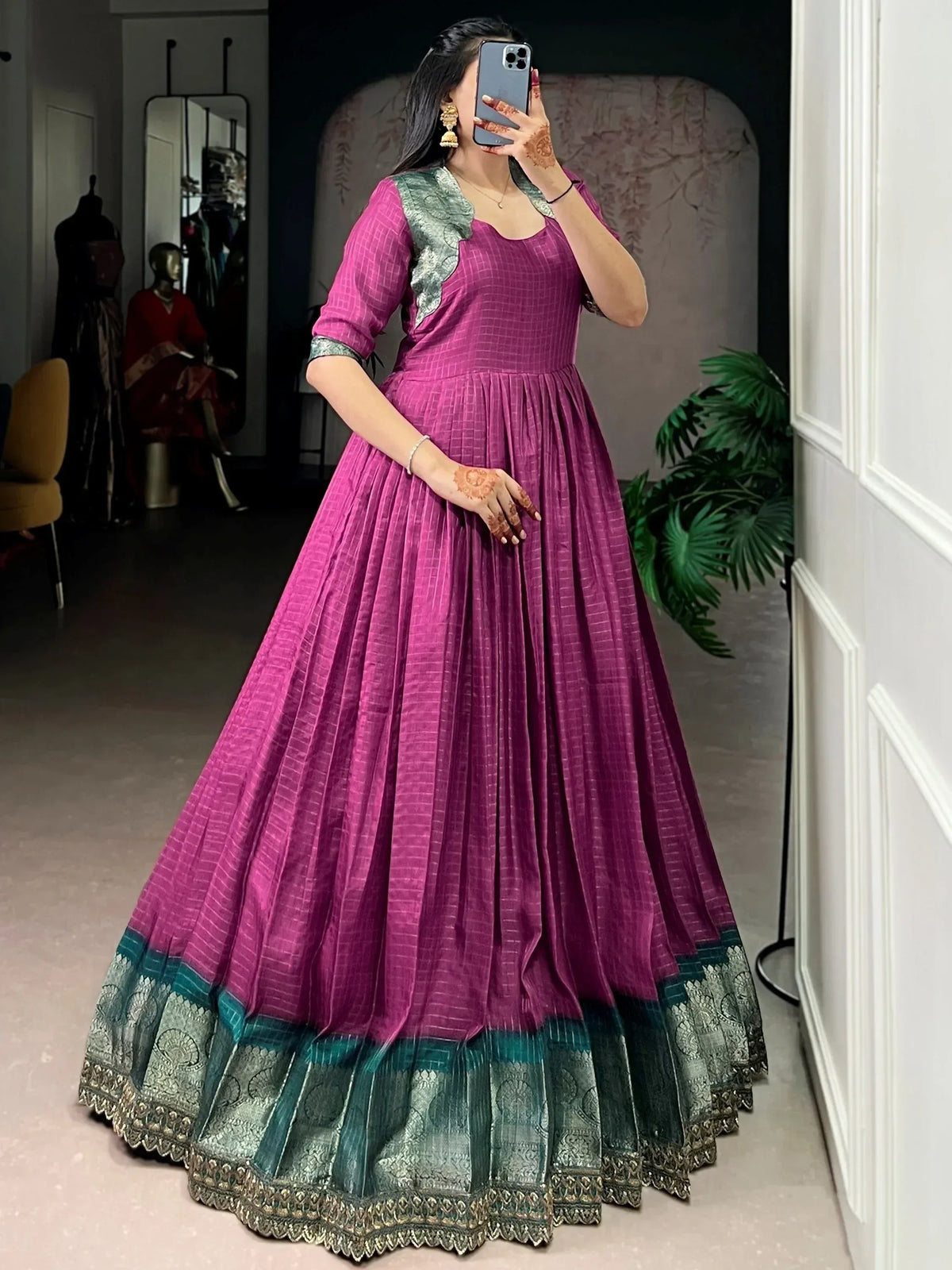 Purple and green ethnic gown with pleated skirt and embroidered border, perfect for Indian occasions.
