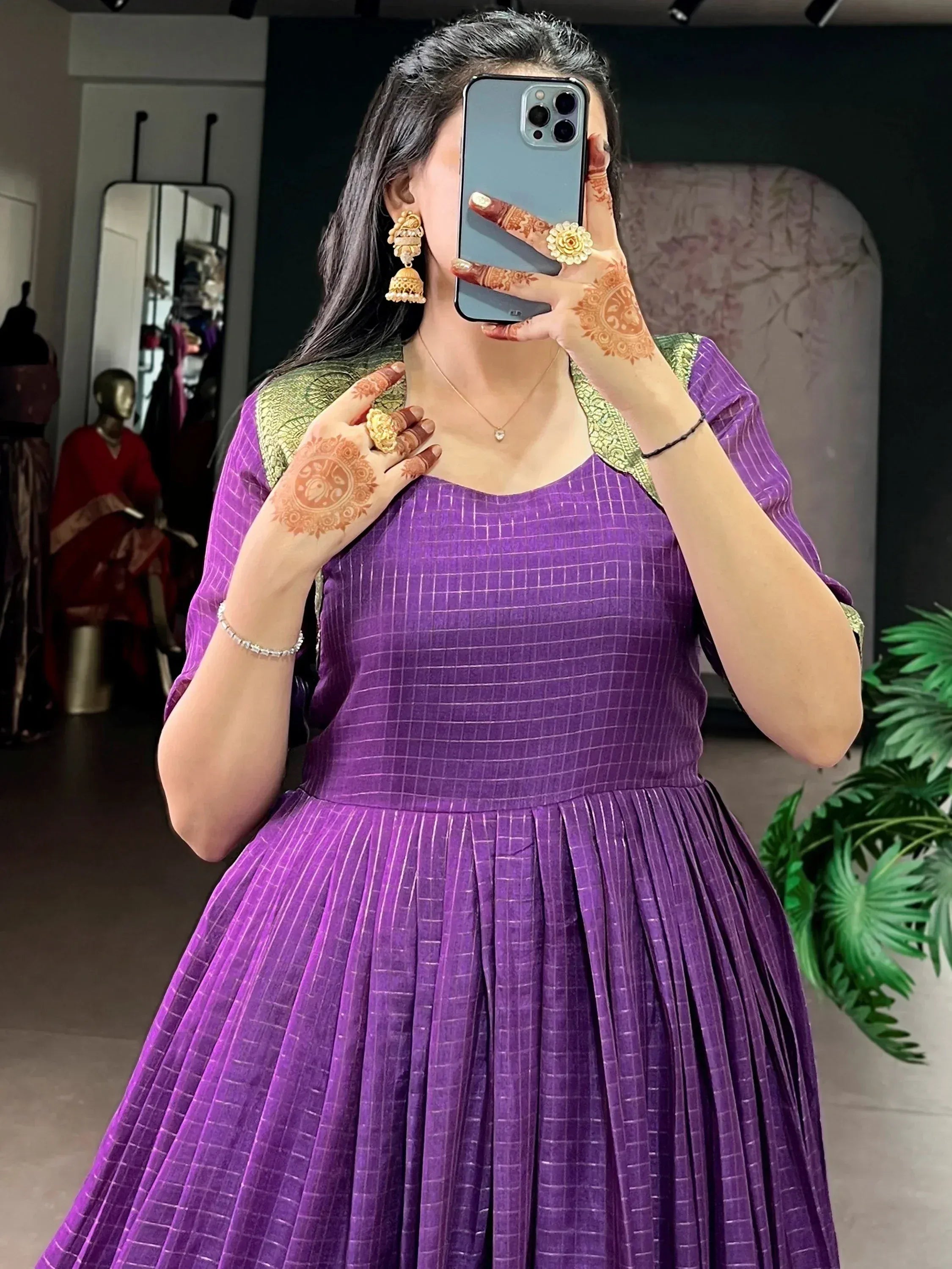 Purple ethnic gown with gold trim, henna hands, jhumka earrings, perfect for Indian occasions