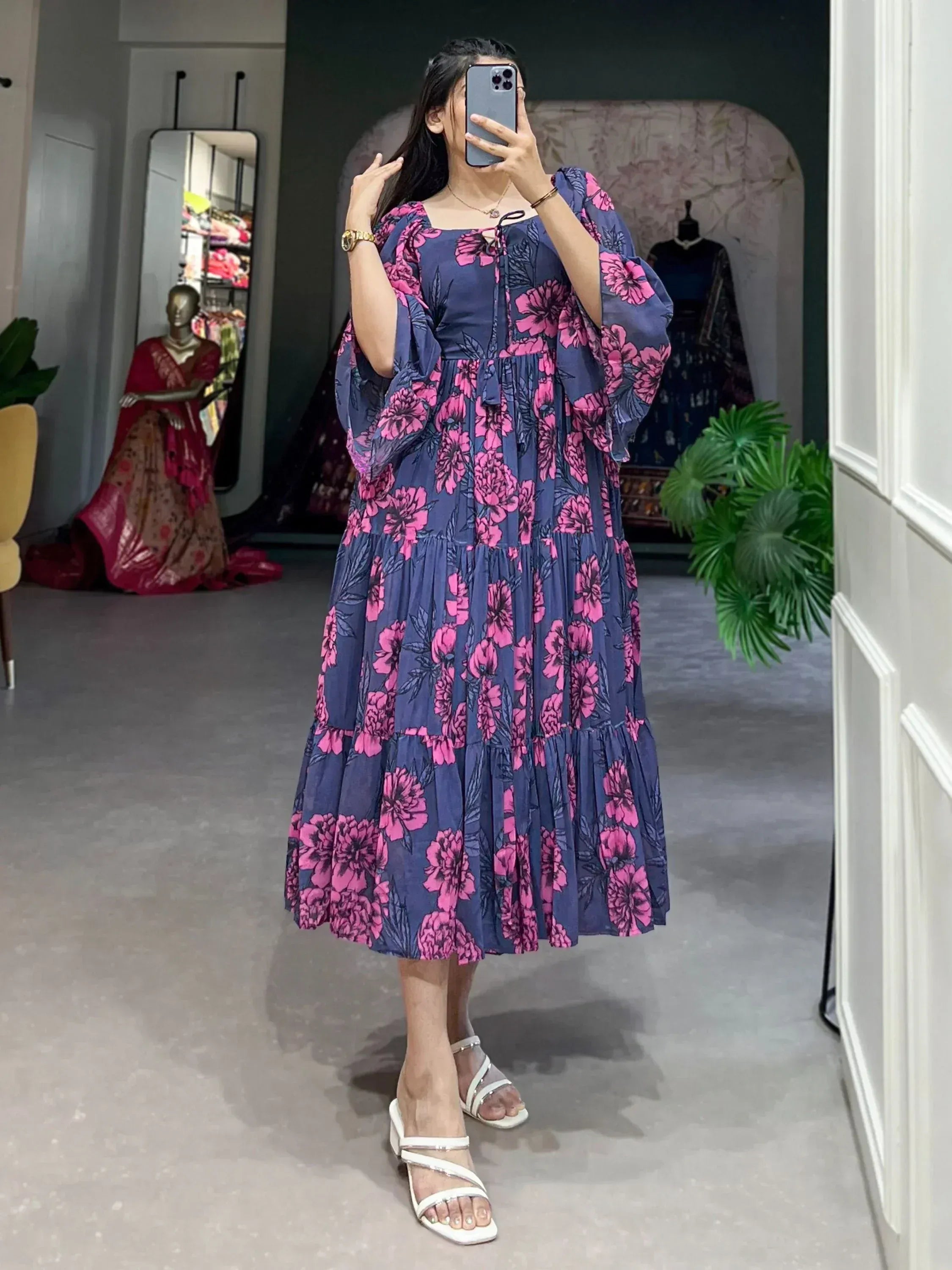 Navy blue ethnic gown with pink floral print, puff sleeves, and tiered skirt, perfect for Indian occasions.