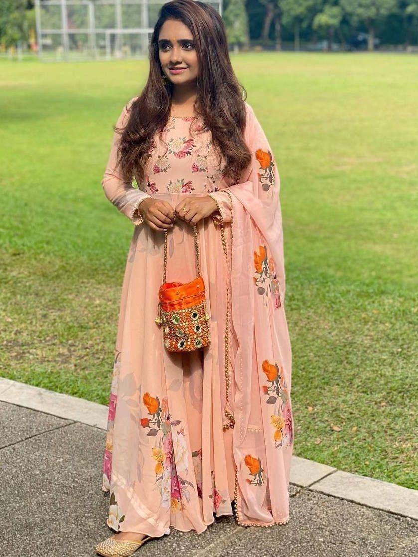 Pink floral printed ethnic salwar kameez with matching dupatta and potli bag, perfect for Indian occasions