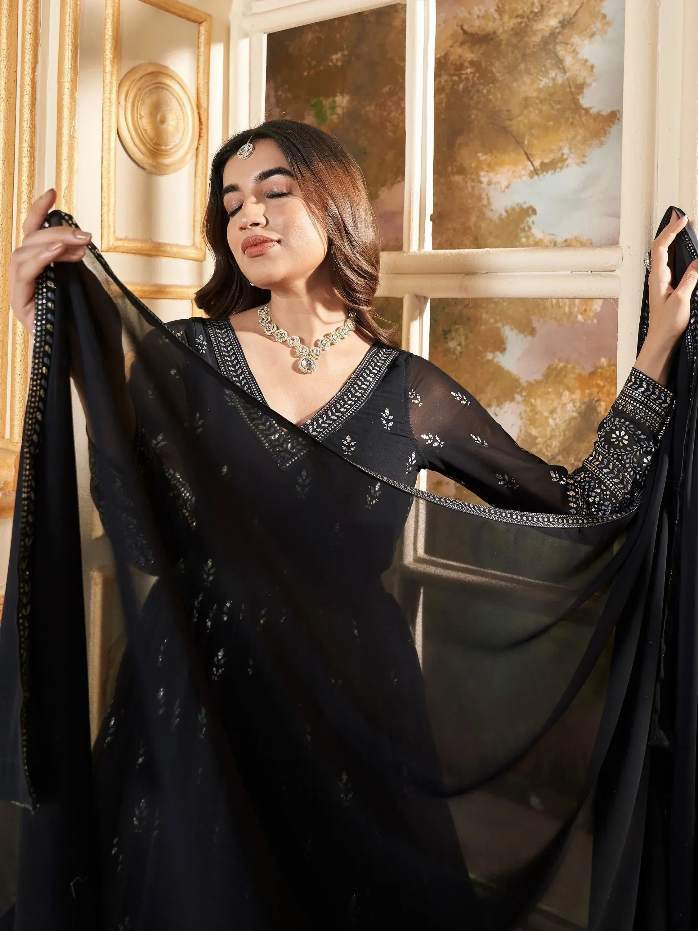 Elegant black embroidered ethnic gown with sheer sleeves and dupatta, perfect for Indian occasions.