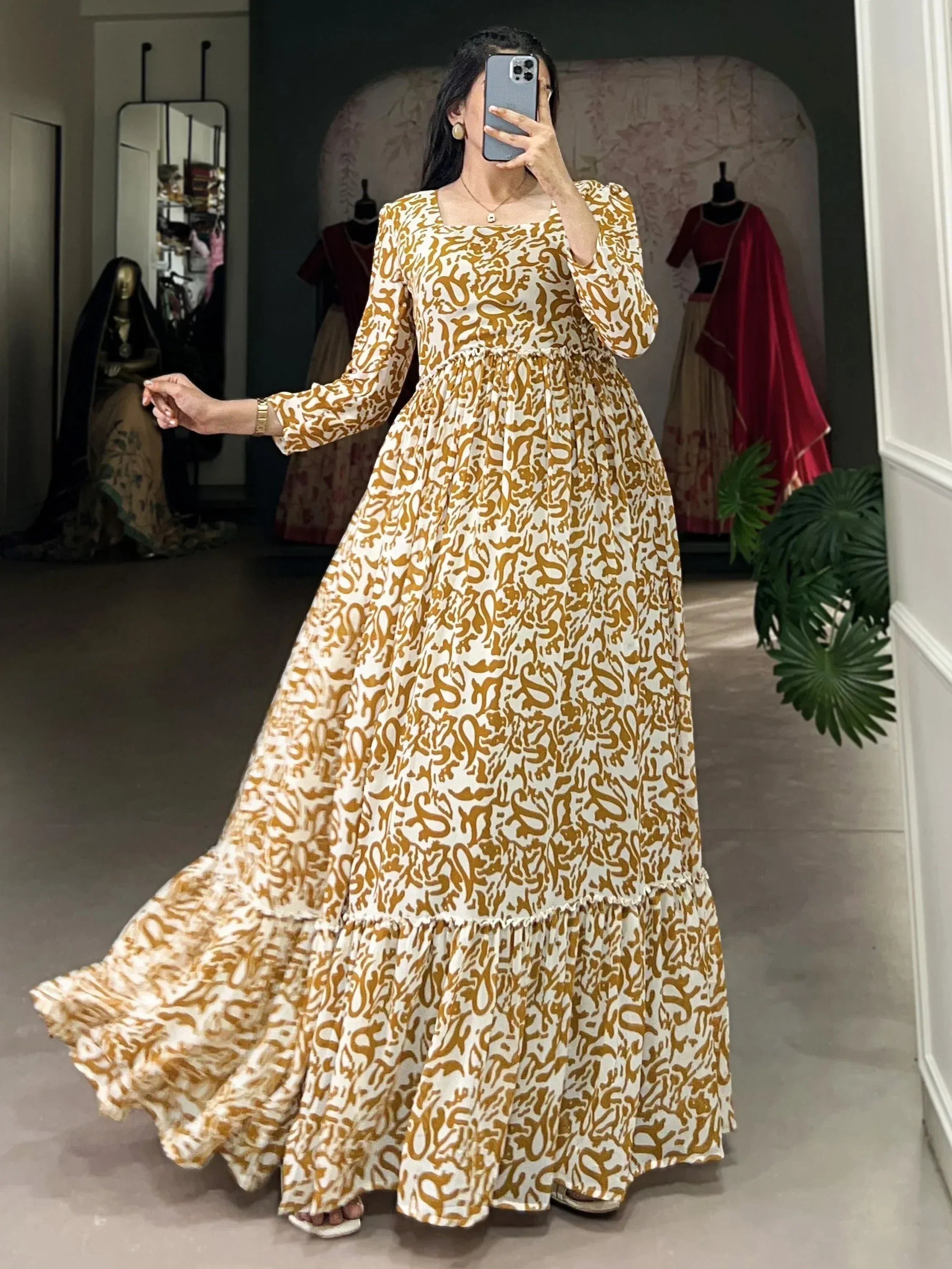 Elegant ethnic gown with gold print, long sleeves, and tiered skirt for festive occasions