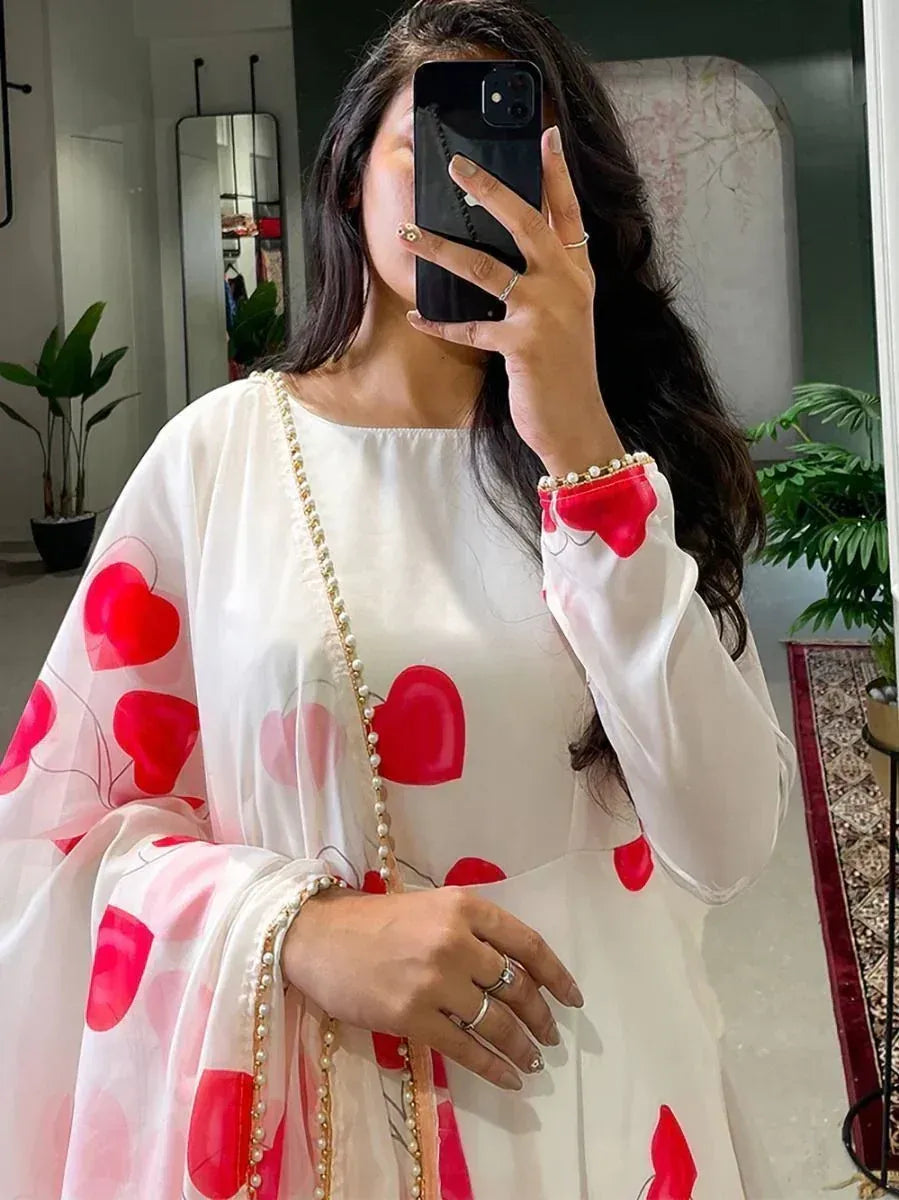 White ethnic gown with red heart print, pearl trim, and sheer sleeves for festive occasions