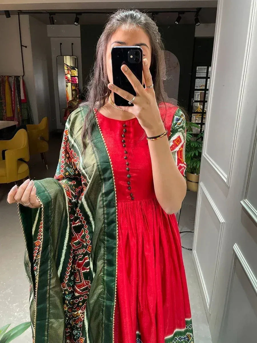 Woman in red ethnic gown with green embroidered dupatta, mirror selfie in boutique