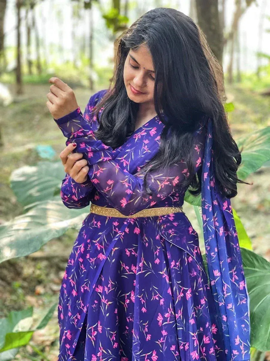 Woman in purple floral ethnic gown with gold belt, forest backdrop
