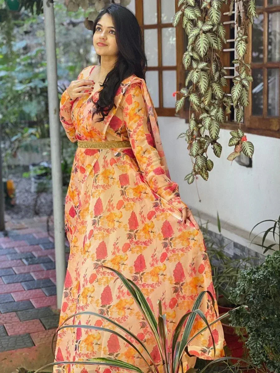 Woman in floral ethnic gown with gold belt, garden setting, Indian designer wear