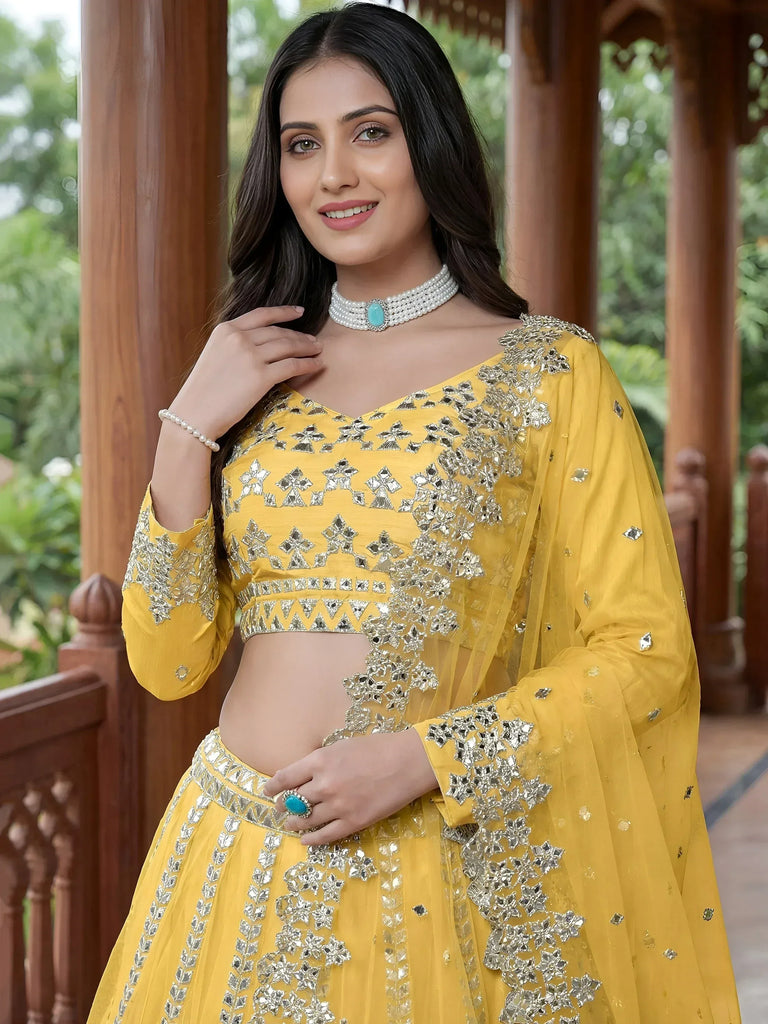 Yellow designer lehenga choli with mirror work, perfect for Indian ethnic wear and festive occasions.