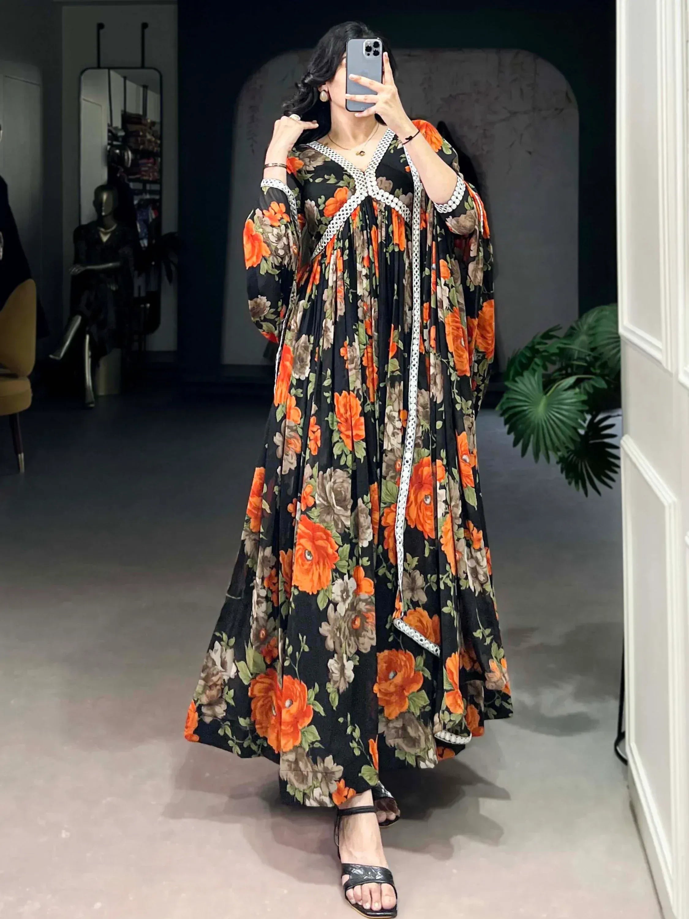 Black floral ethnic gown with orange roses and white lace trim, perfect for Indian occasions.