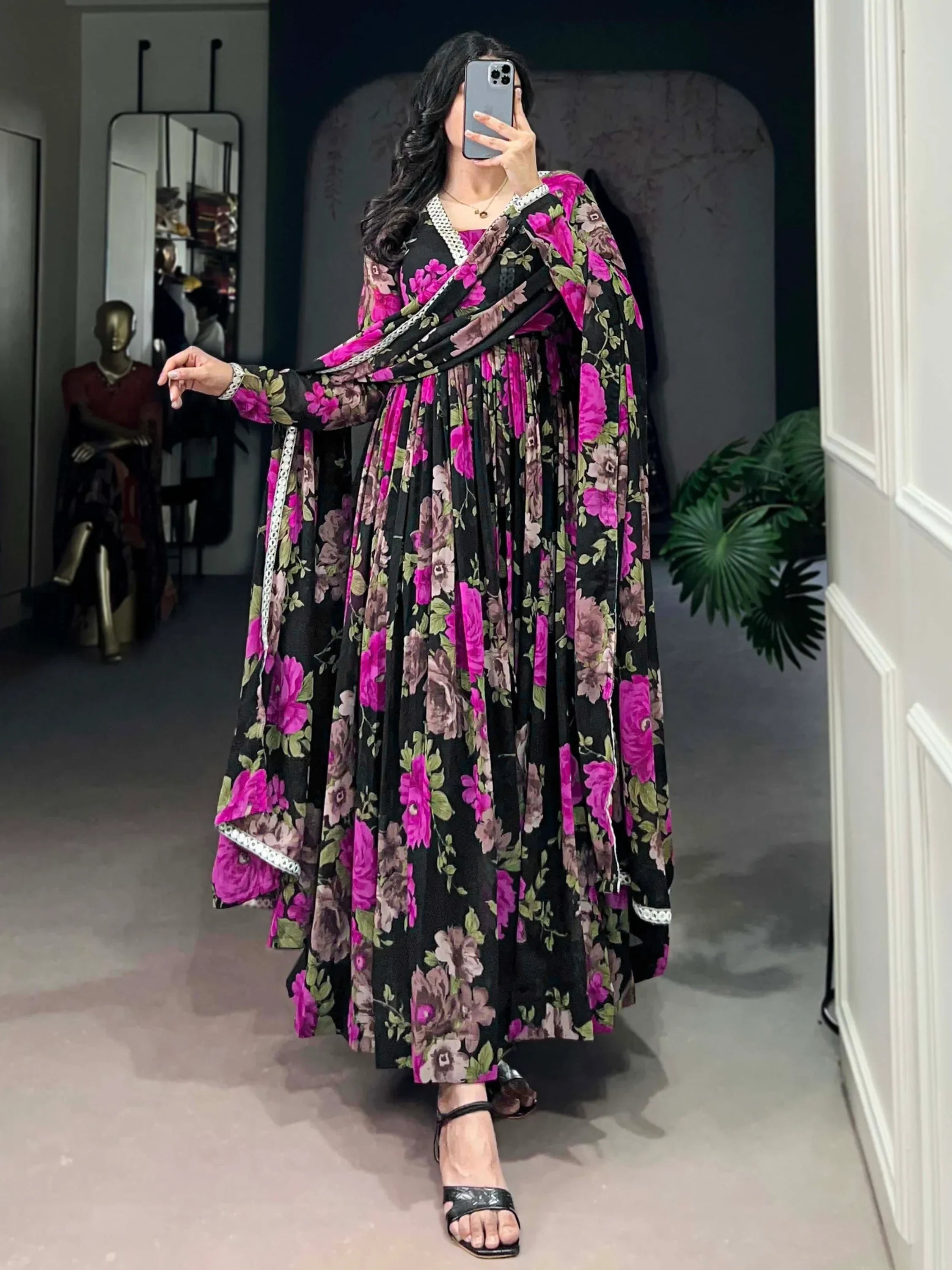 Woman wearing a black floral Indian Anarkali suit with pink and purple flowers
