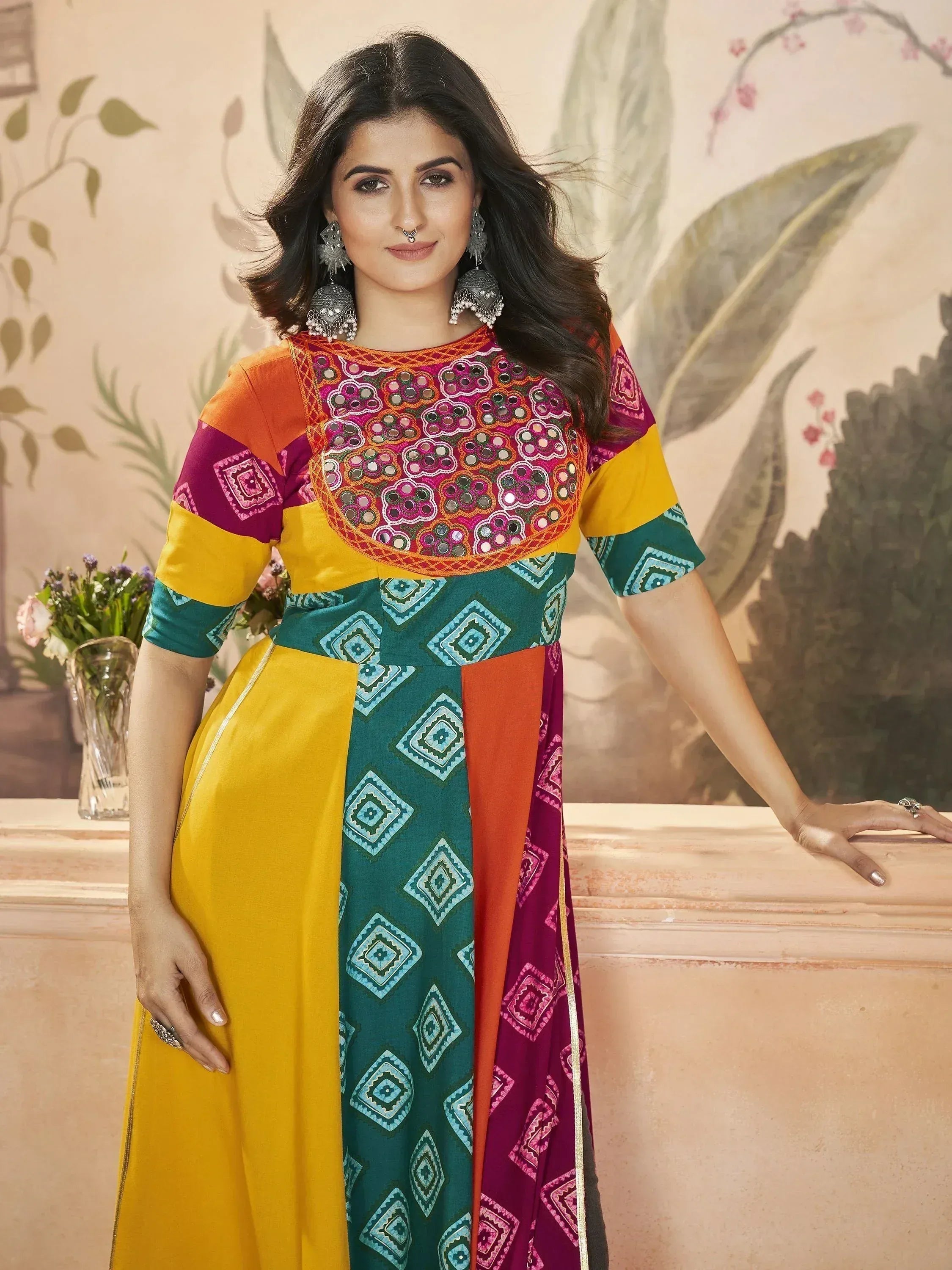 Colorful ethnic gown with mirror work and geometric prints, perfect for festive occasions