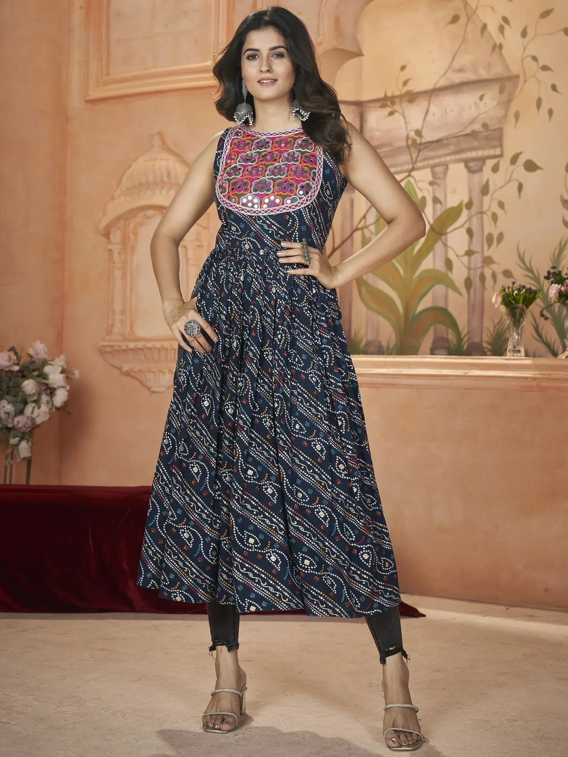 Woman in navy blue printed ethnic gown with mirror work, styled with jeans and heels for festive occasions