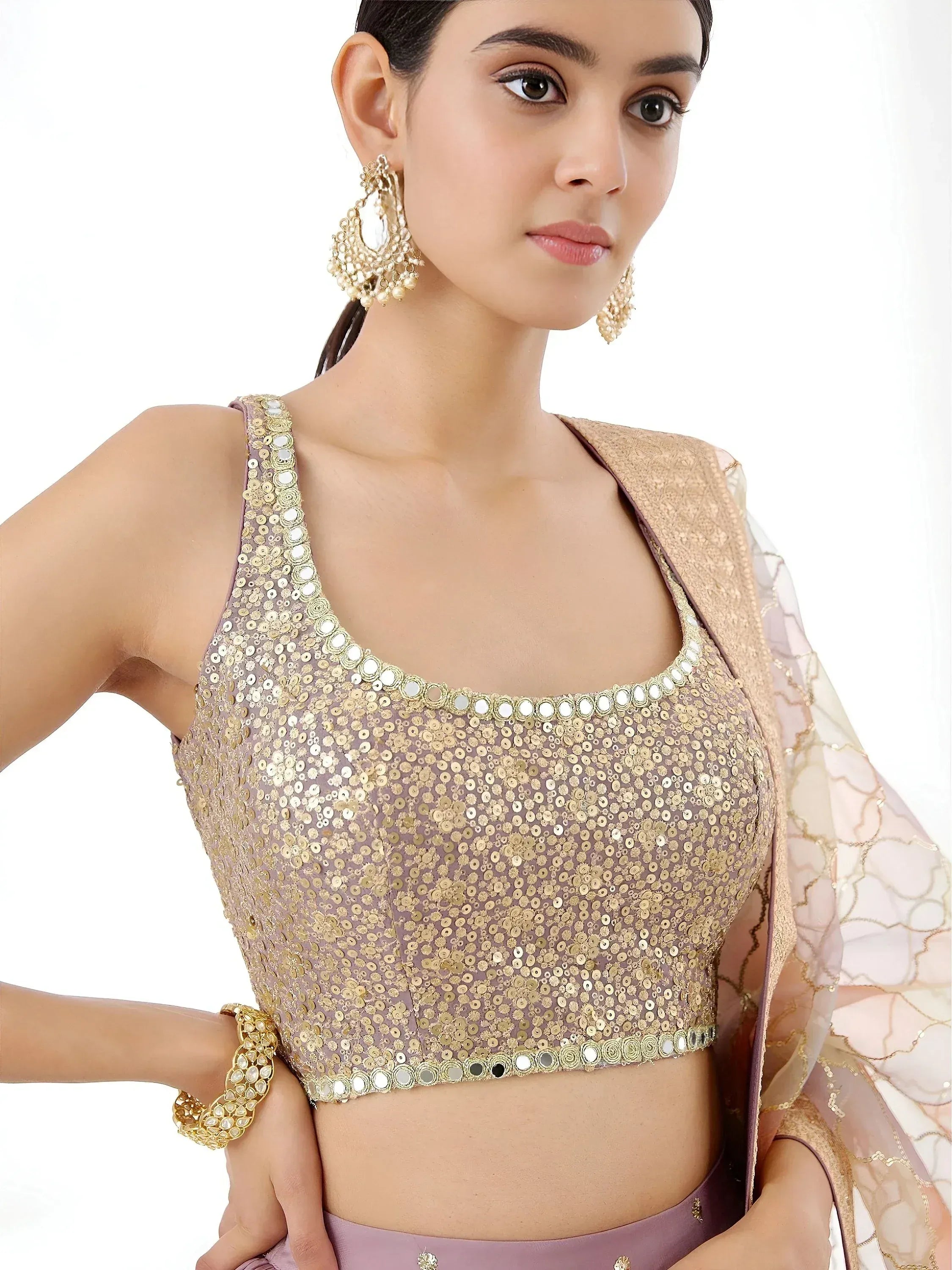 Elegant mauve lehenga choli with gold sequin blouse and mirror work, paired with statement earrings