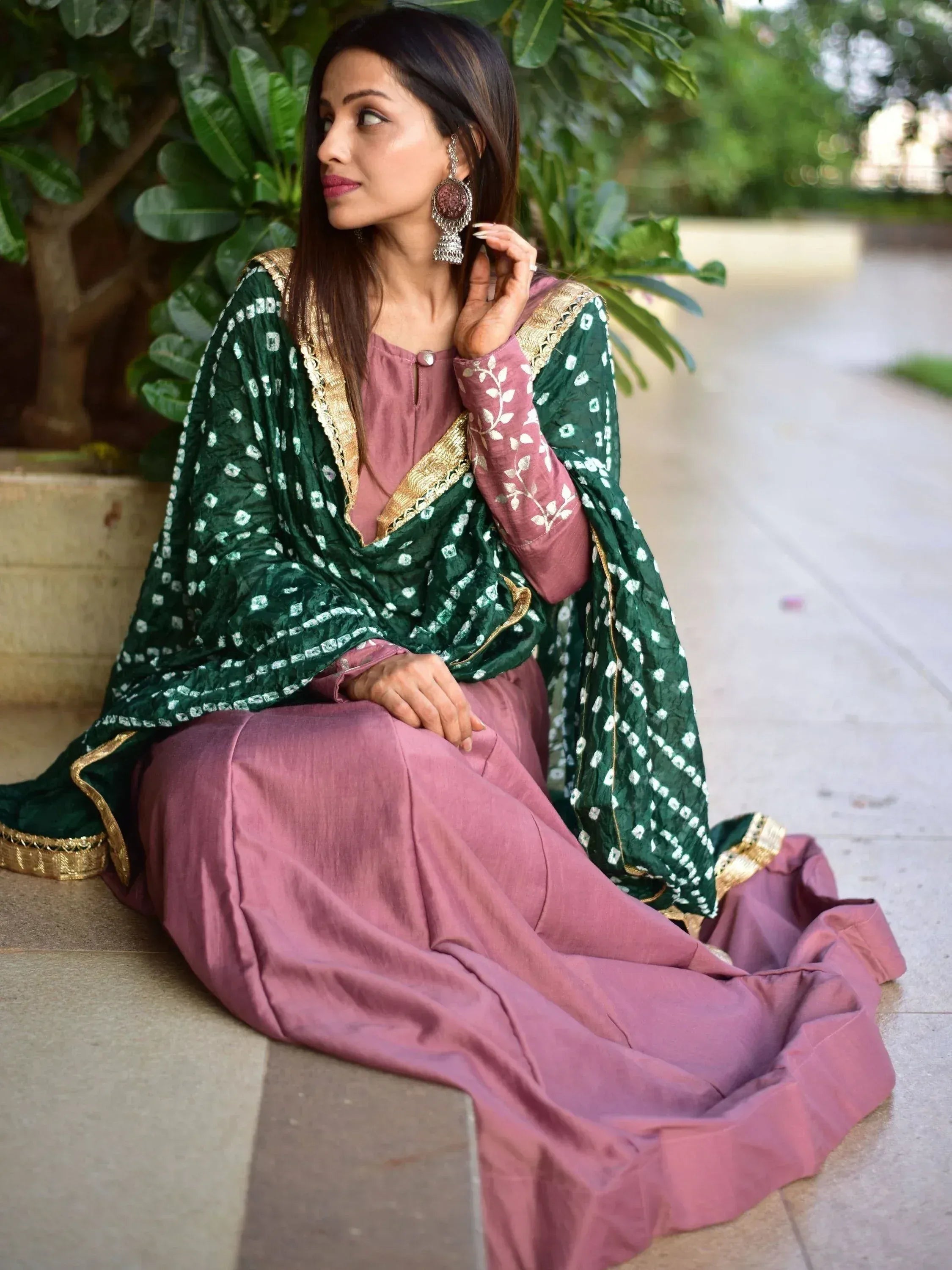 Elegant pink salwar kameez with green dupatta, gold embroidery, and traditional earrings