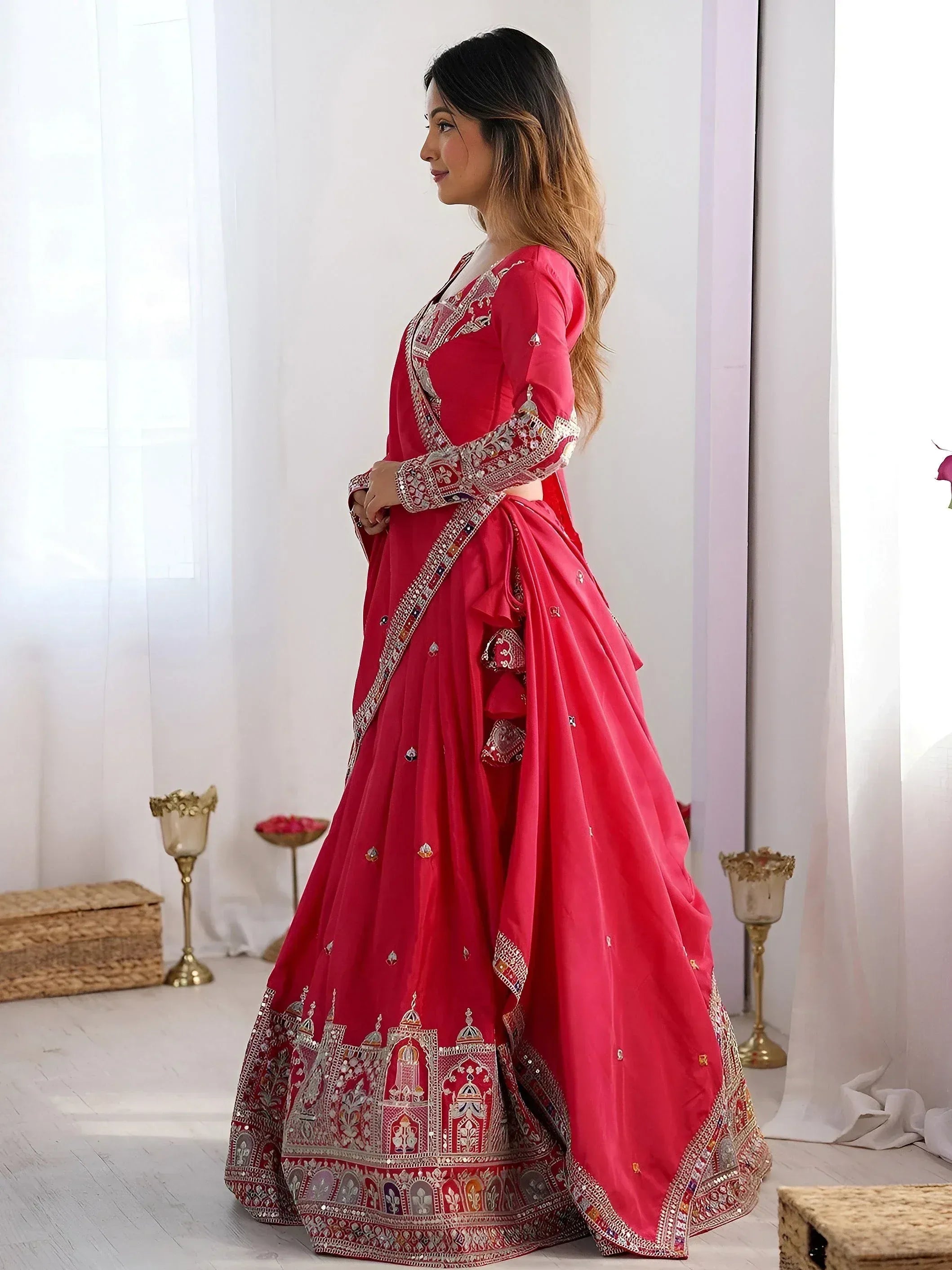 Red embroidered lehenga choli with intricate mirror work, perfect for Indian weddings and festive occasions.