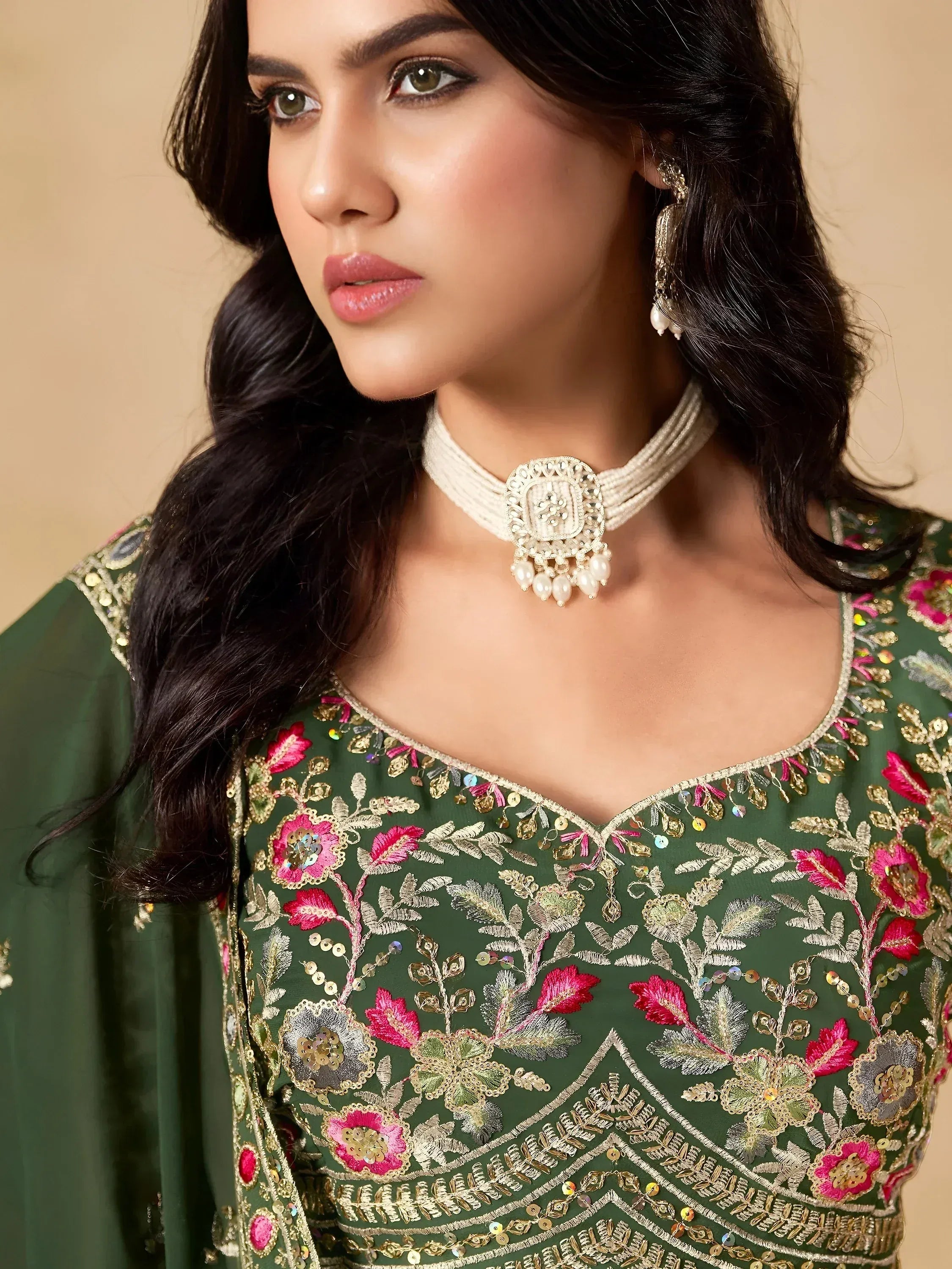 Green embroidered ethnic gown with floral gold detailing and pearl choker necklace