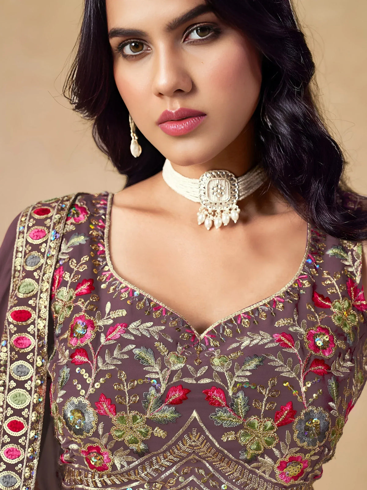 Elegant Indian ethnic wear with floral embroidery, sequins, and gold detailing on a mauve designer top.