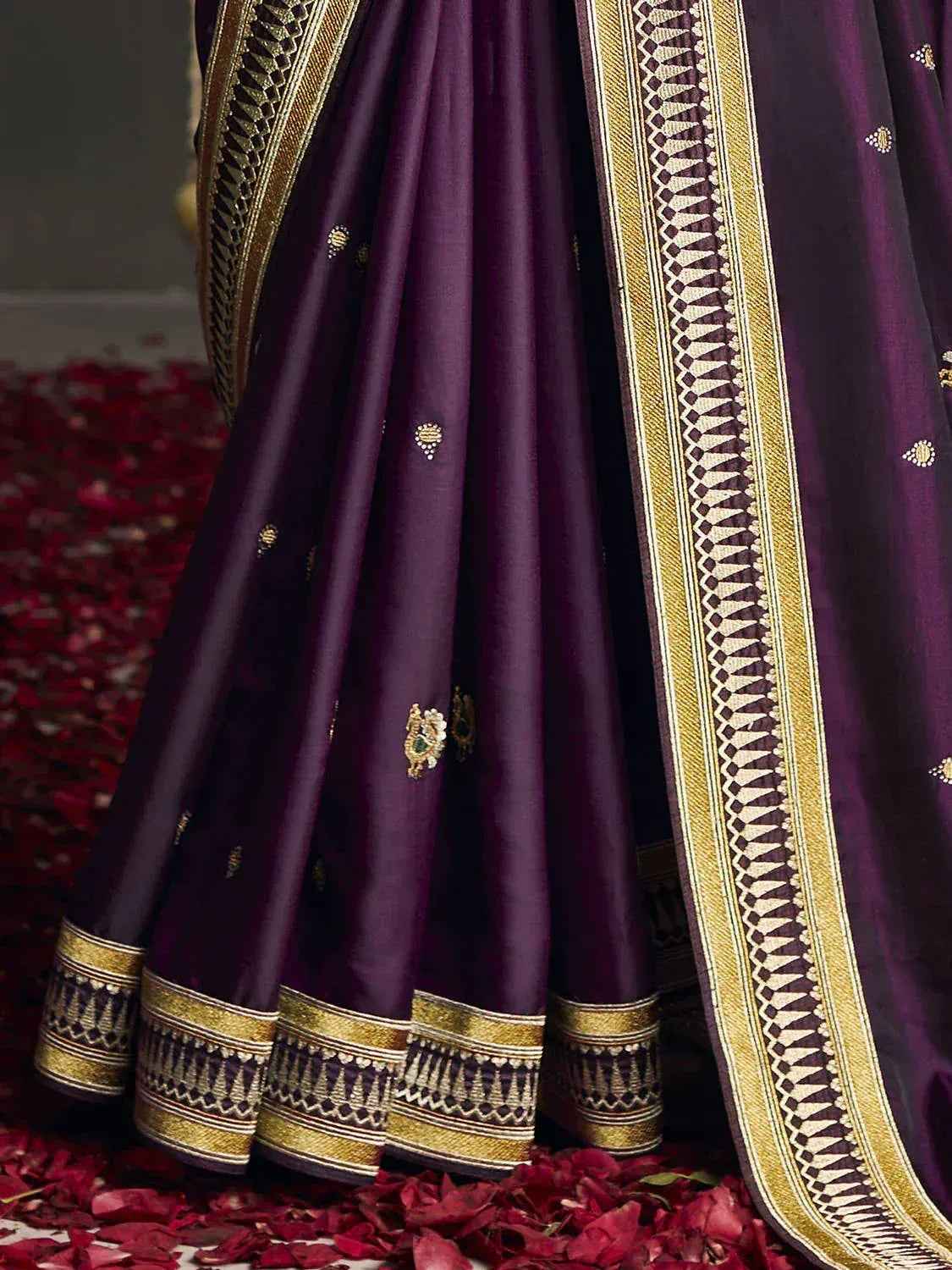 Purple designer lehenga with gold embroidery and border, floral motifs, rose petals on floor