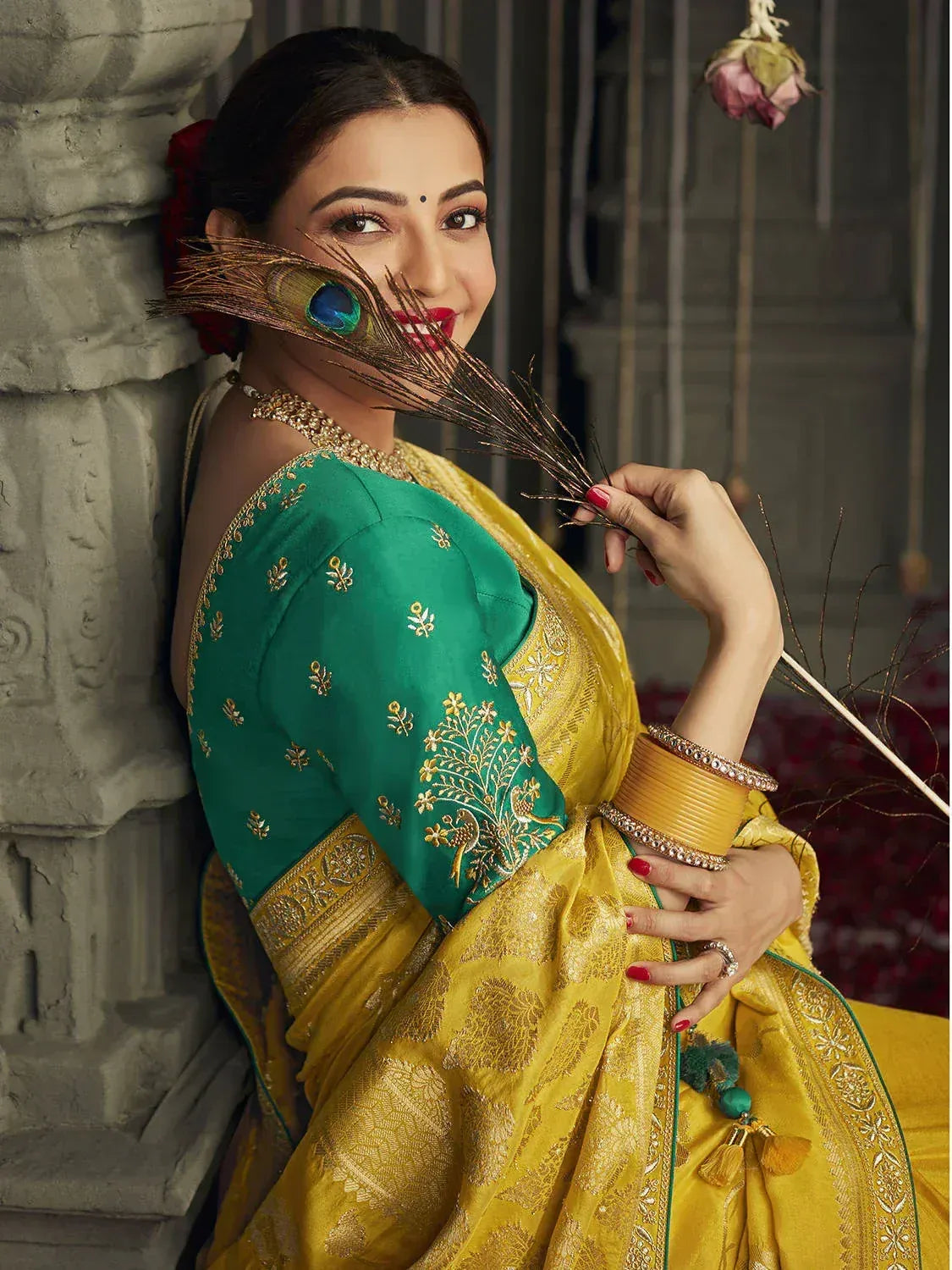 Woman in yellow and green embroidered saree with peacock feather, traditional Indian ethnic wear