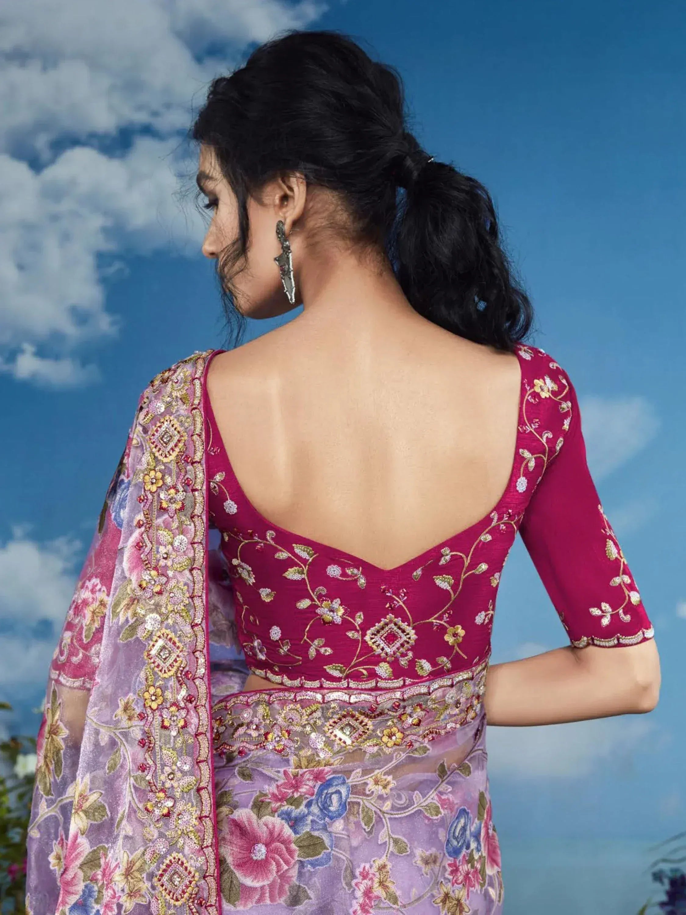 Back view of woman in embroidered magenta blouse and floral saree, showcasing Indian ethnic wear design