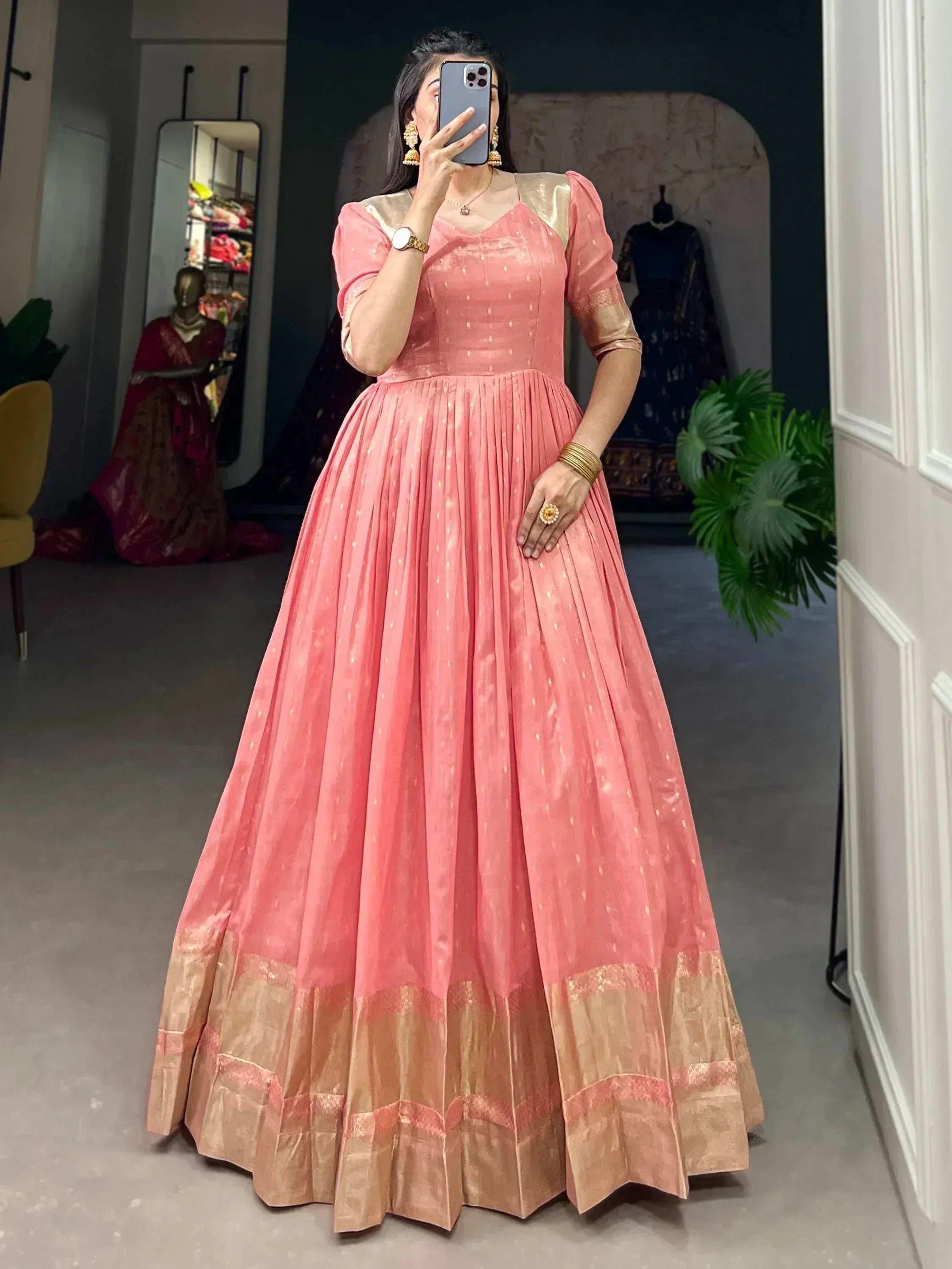 Pink ethnic gown with gold accents, pleated skirt, and puff sleeves for Indian occasions
