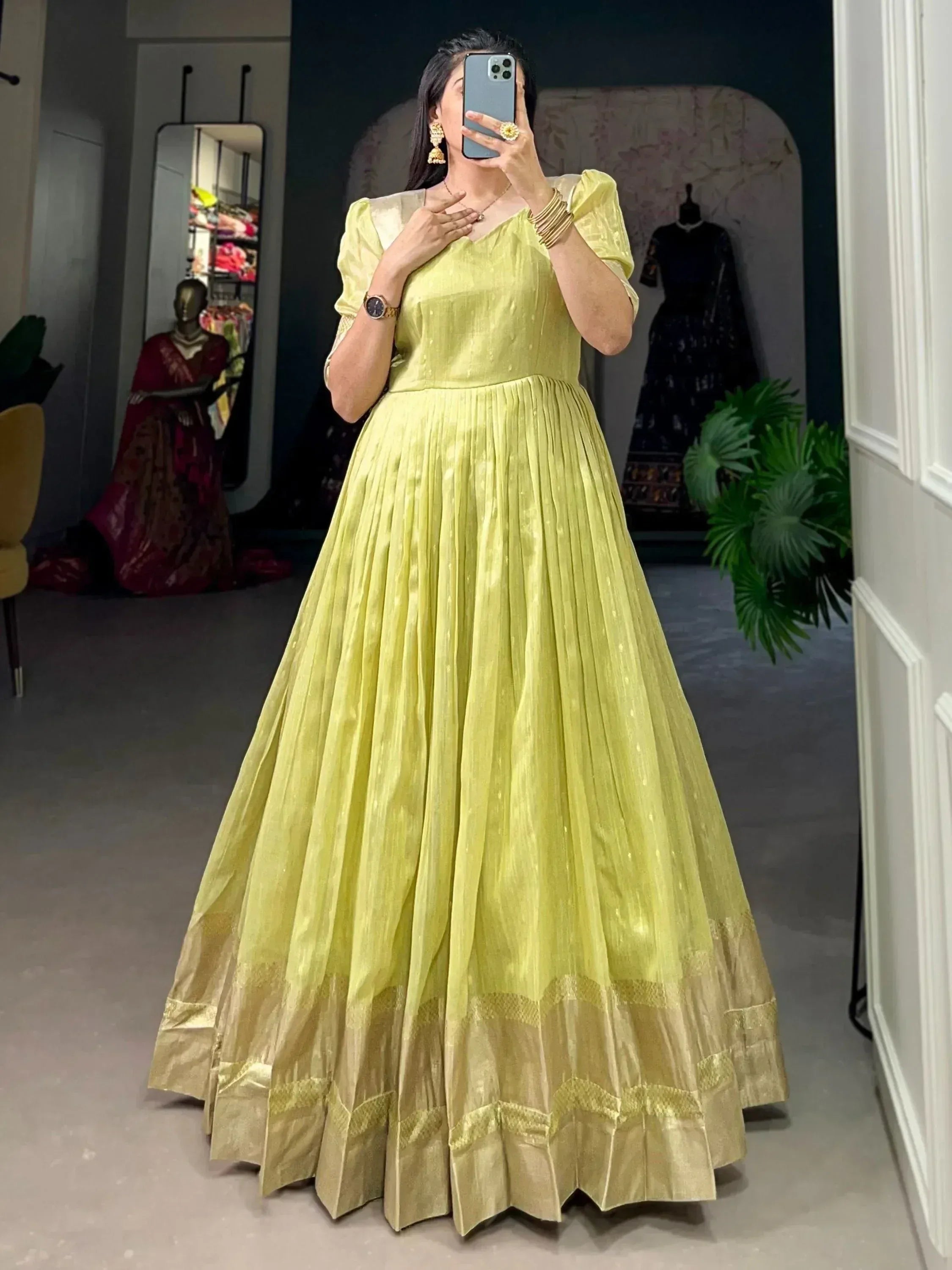 Lemon green ethnic gown with pleated skirt and gold border, perfect for Indian occasions