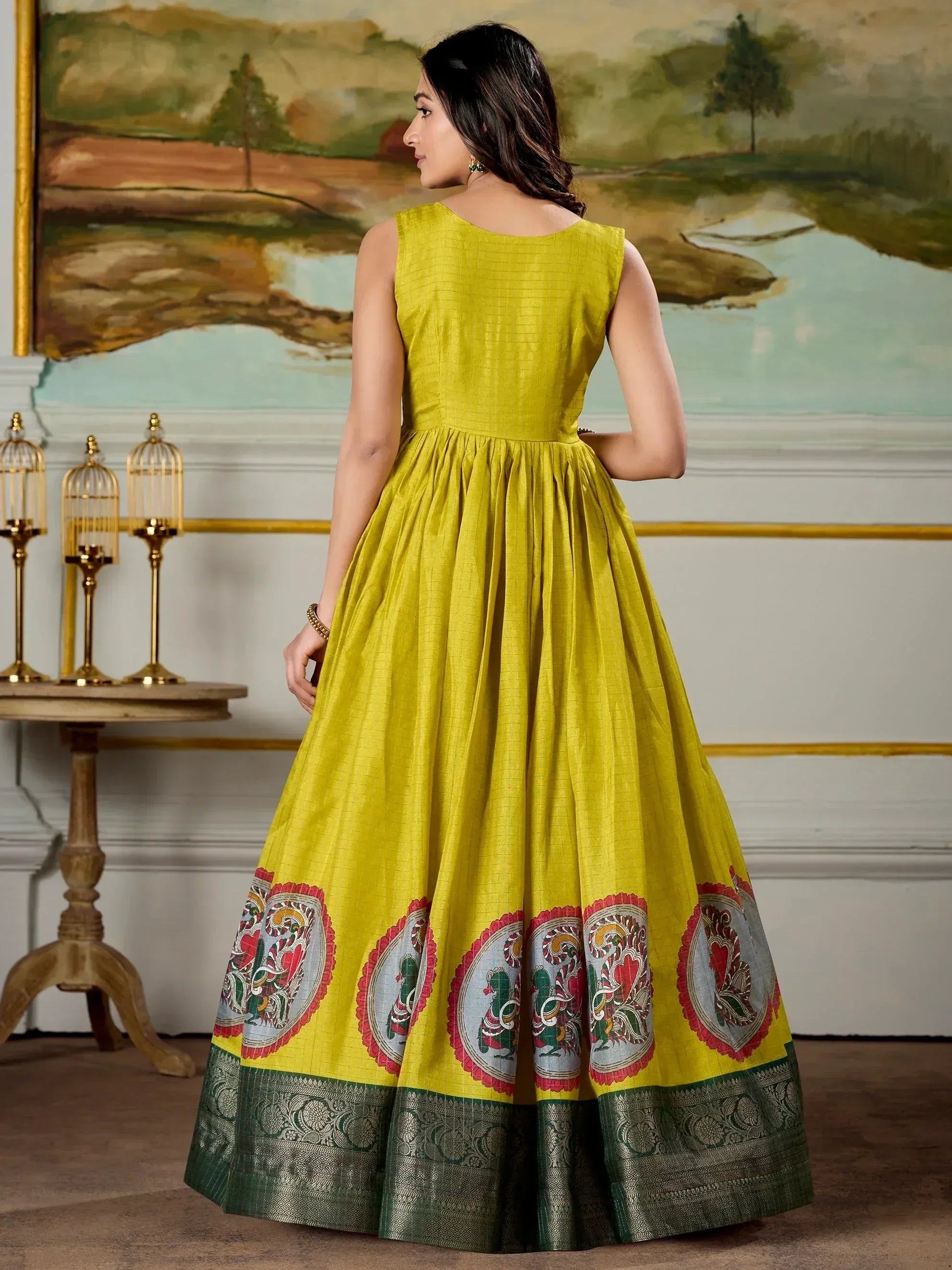Yellow ethnic gown with printed border and green lace, perfect for Indian occasions