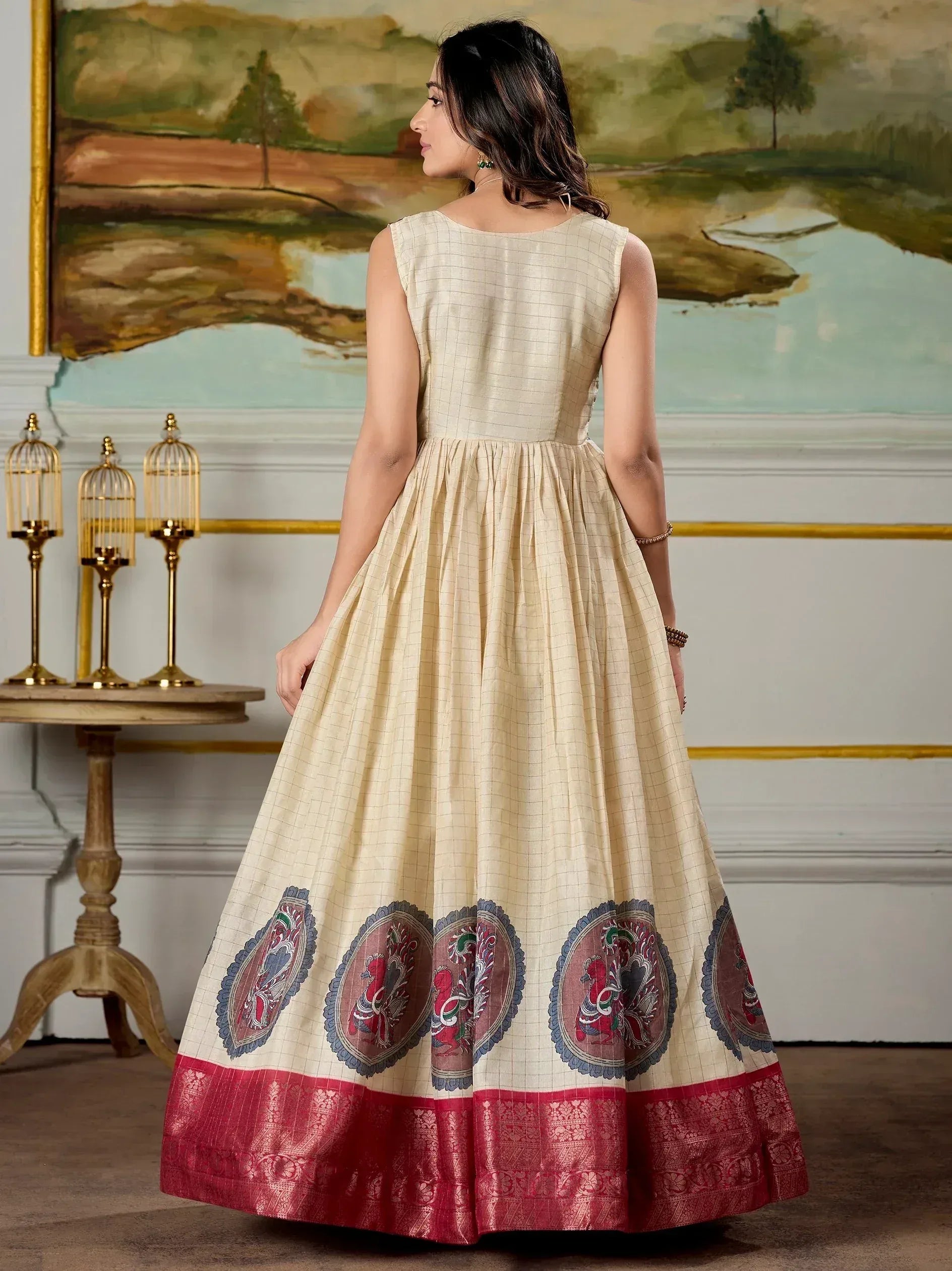Cream ethnic gown with peacock embroidery and red border, perfect for Indian occasions