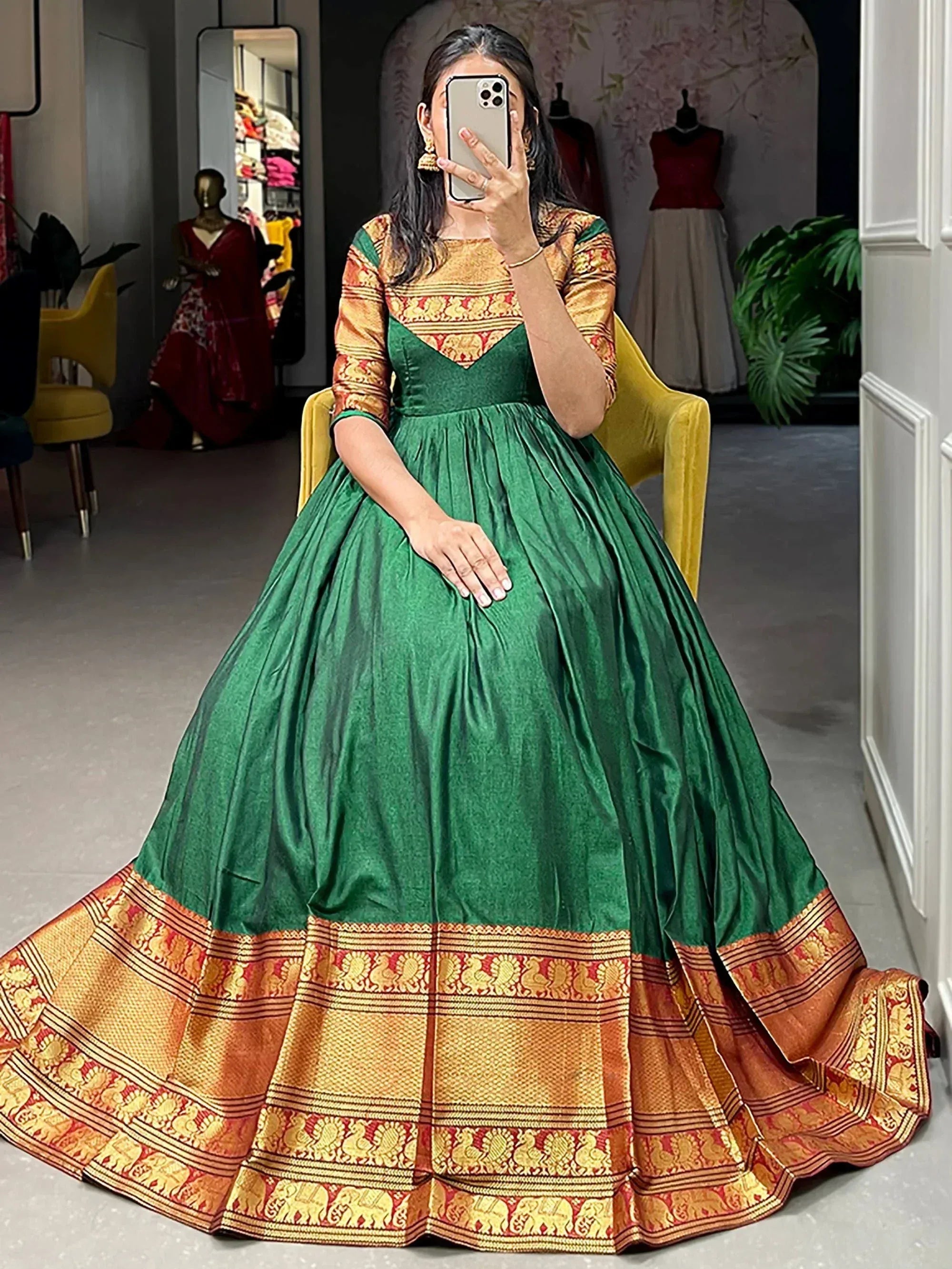 Emerald green ethnic gown with gold and red temple border, perfect for Indian festive occasions.