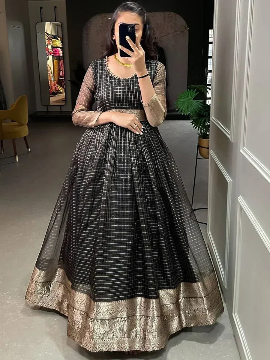 Black and gold ethnic gown with checkered pattern and embroidered hem, perfect for Indian festive occasions.