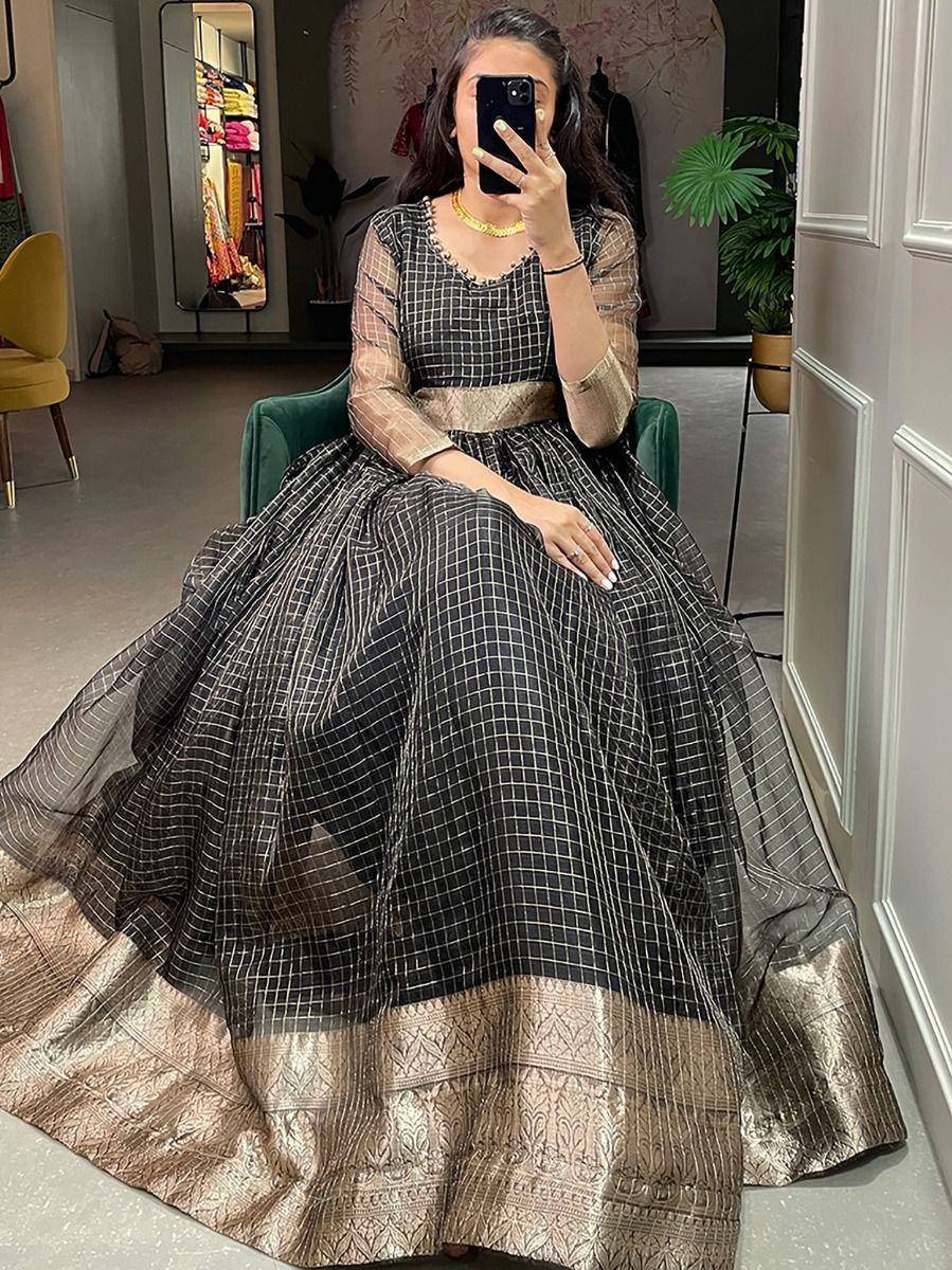 Black and gold ethnic gown with checkered pattern and embroidered border, perfect for Indian festive occasions.