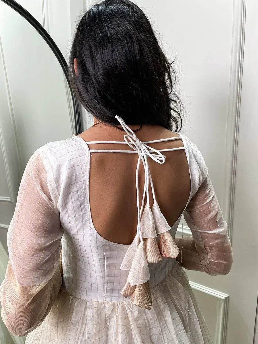 Back view of woman in ethnic gown with tie-up back and ruffle details, perfect for Indian occasions