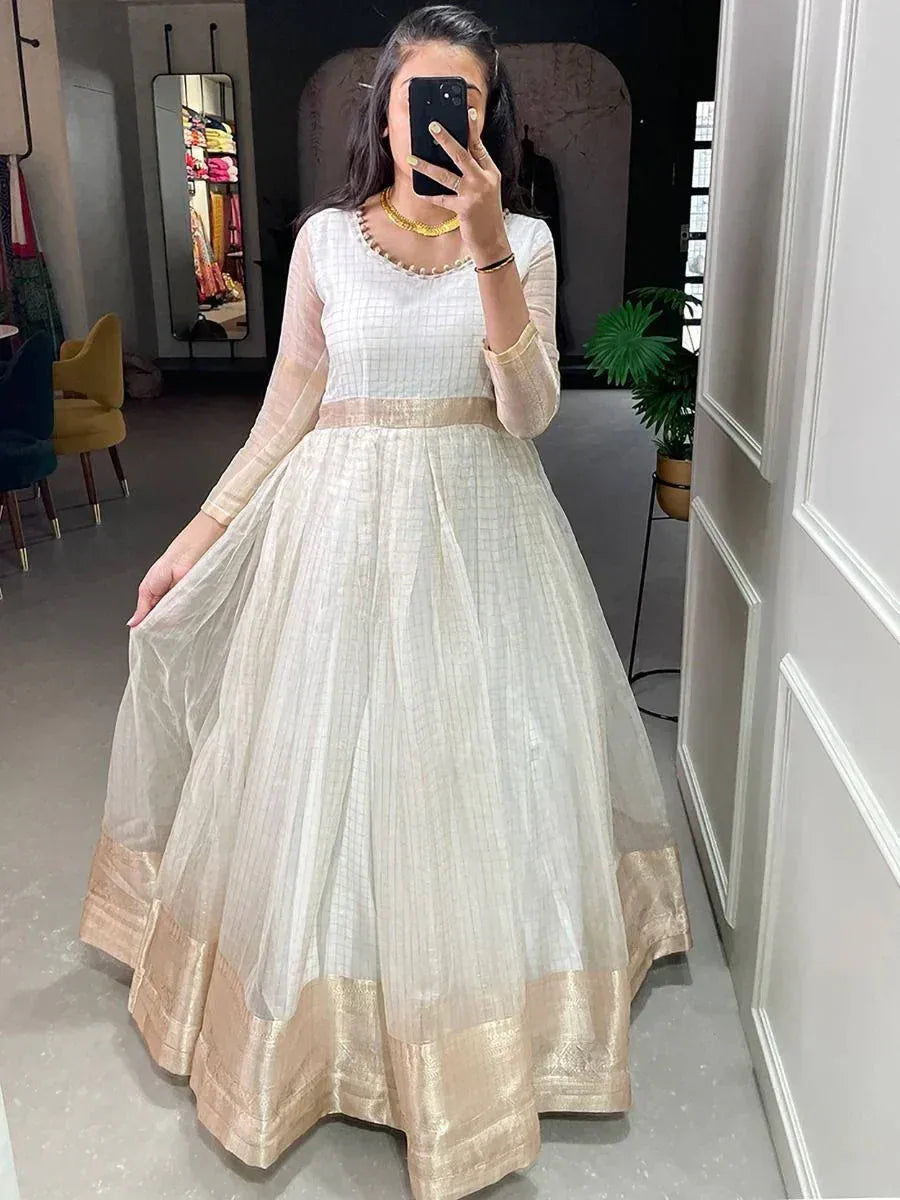 White and gold ethnic gown with sheer sleeves and pleated skirt, perfect for Indian occasions