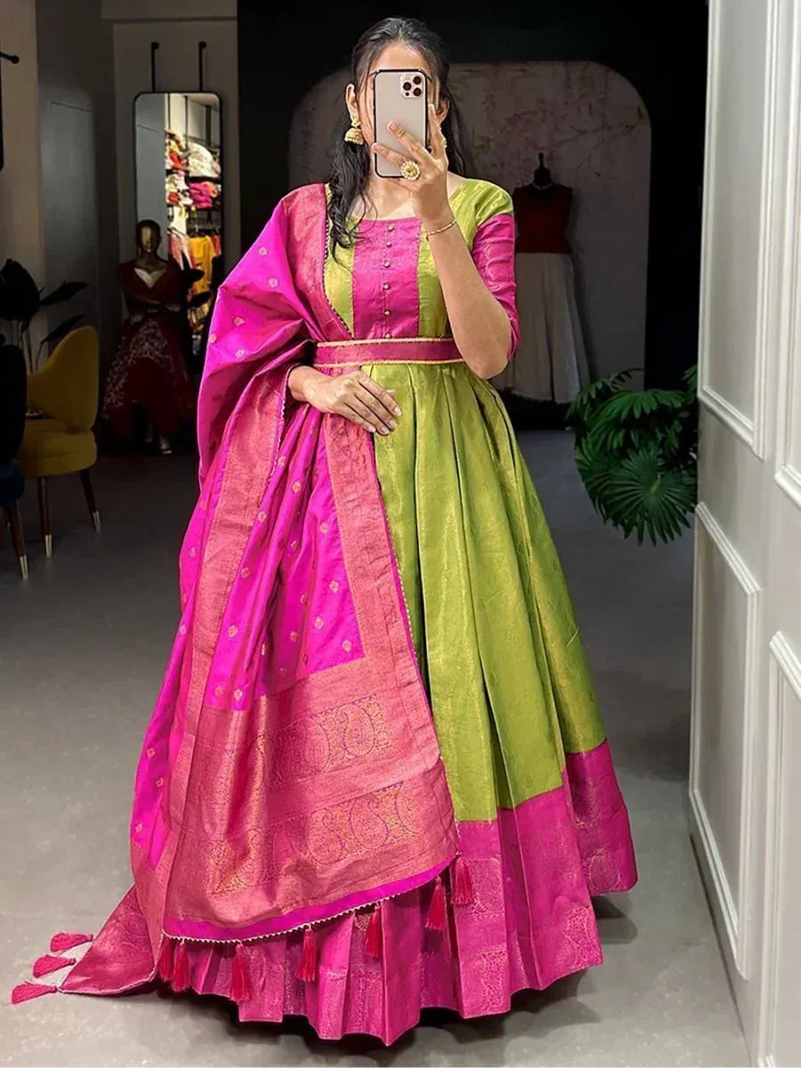 Woman wearing a green and pink silk lehenga choli with dupatta, posing indoors