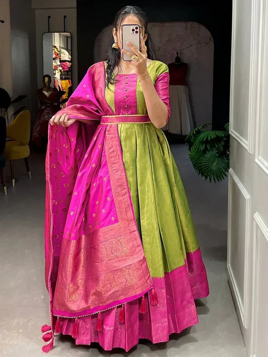 Woman wearing a pink and green silk lehenga choli with gold detailing and dupatta
