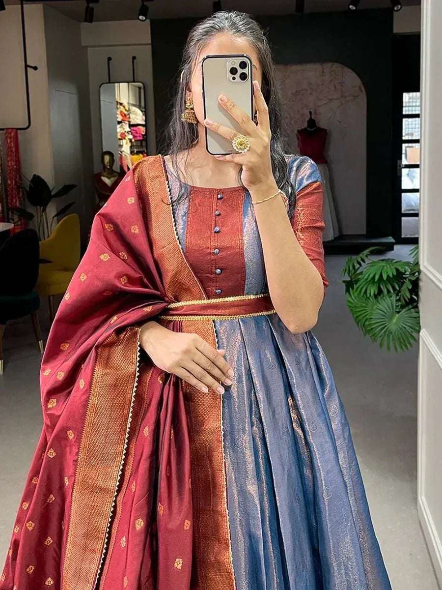 Woman in maroon and blue ethnic gown with gold detailing, perfect for Indian occasions